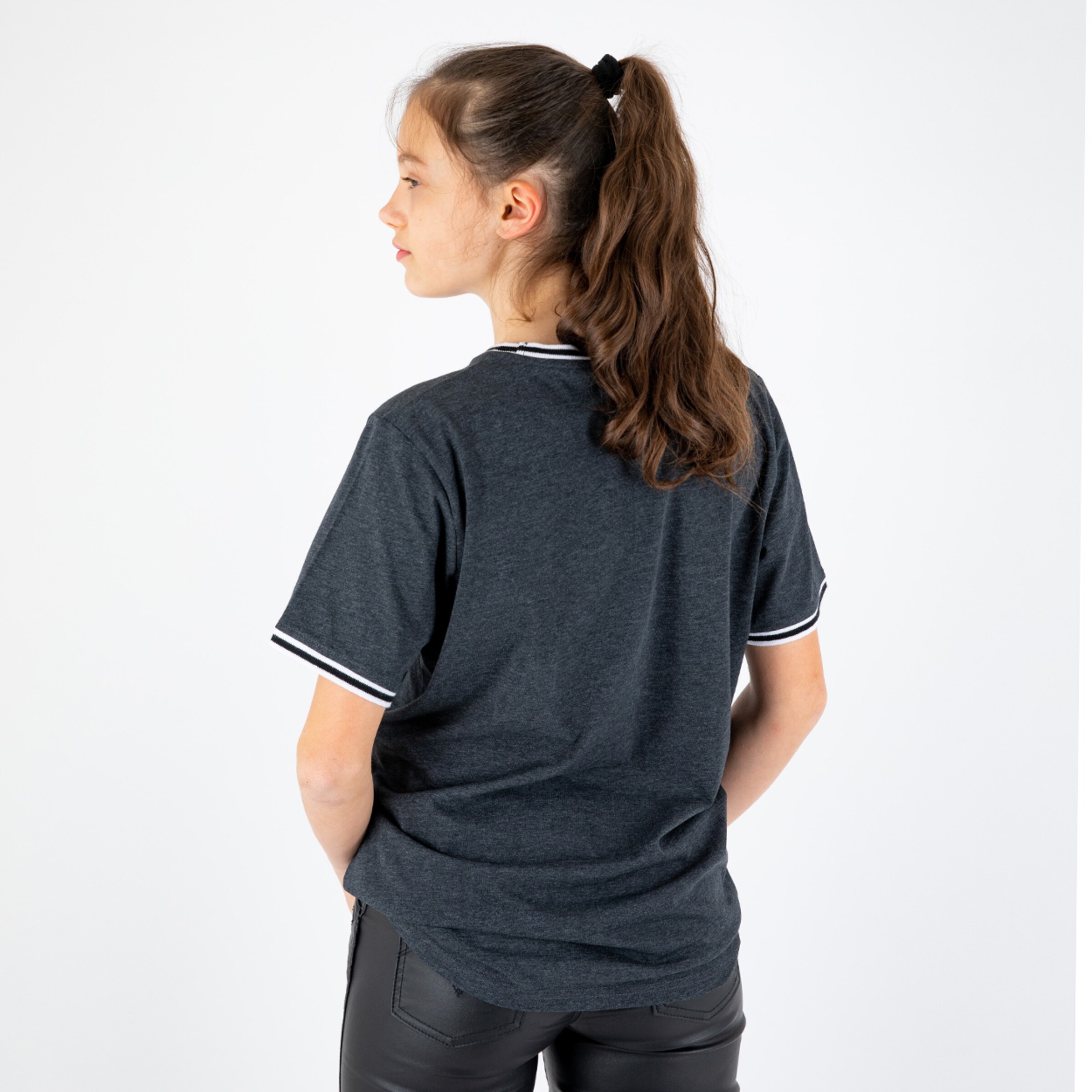 A young girl wearing a dark T-shirt with white stripes on the sleeves viewed from the back.