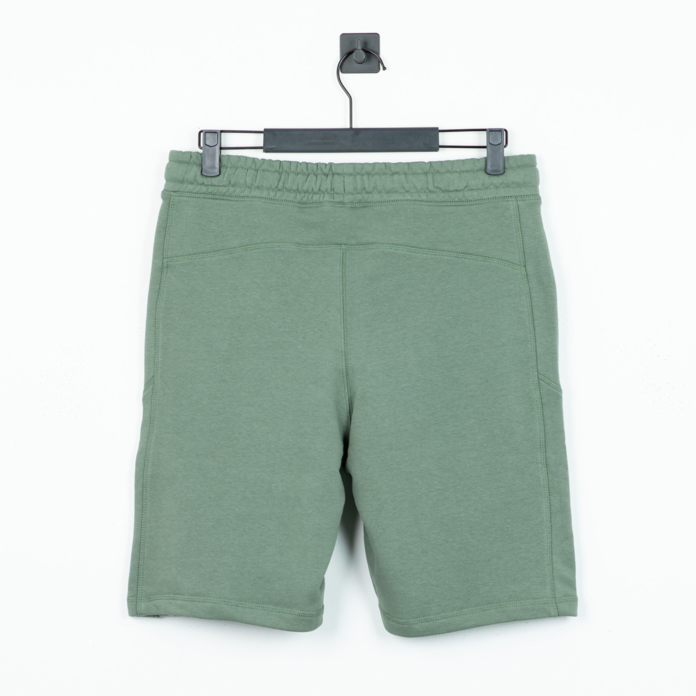 Grüne Sportshorts mit elastischem Bund hinten gesehen.