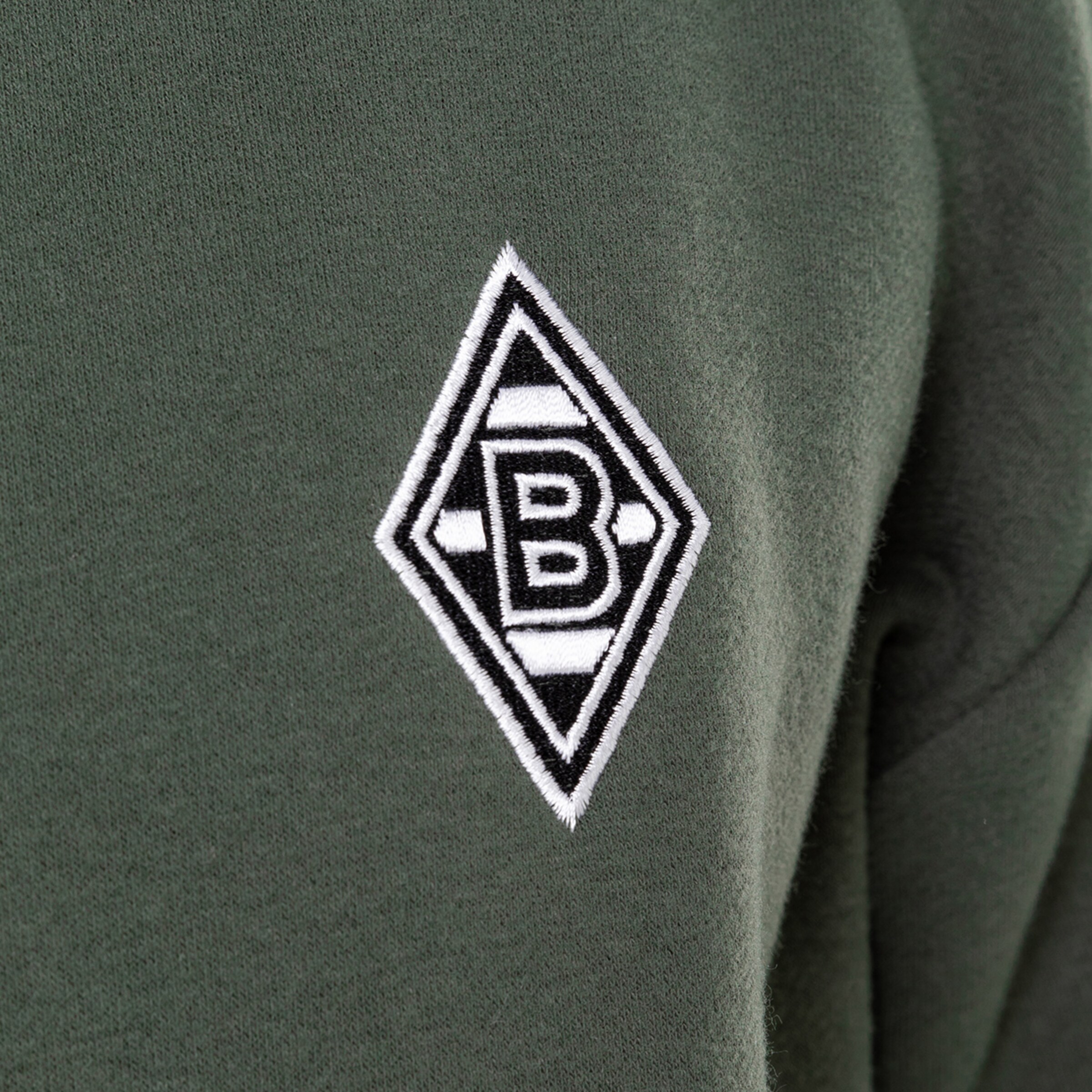 Grüner Pullover mit dem weißen Borussia Mönchengladbach-Logo auf der linken Brust.