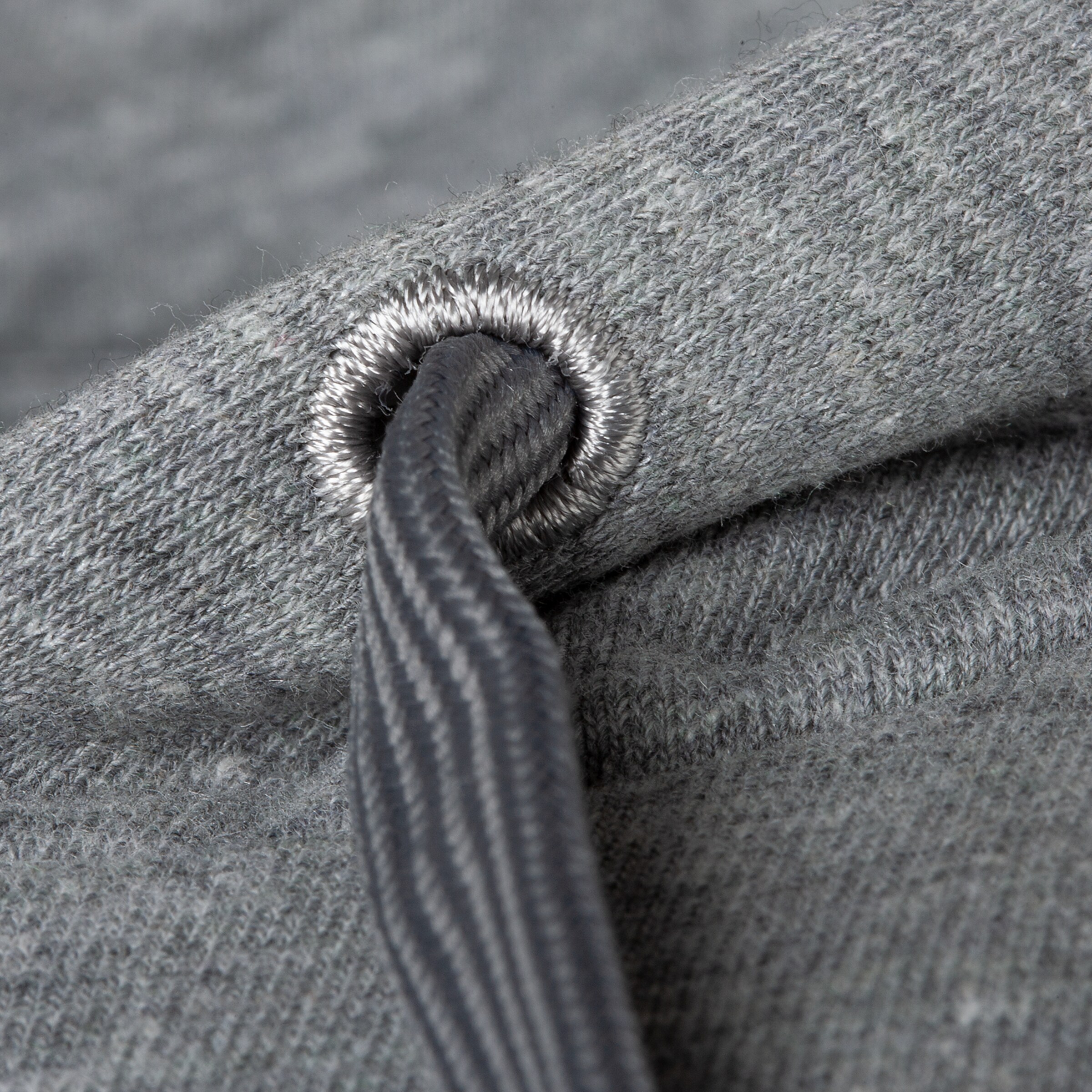 Detailansicht eines grauen Sweatshirts mit einem Kordelzug und einem Ösenverschluss.