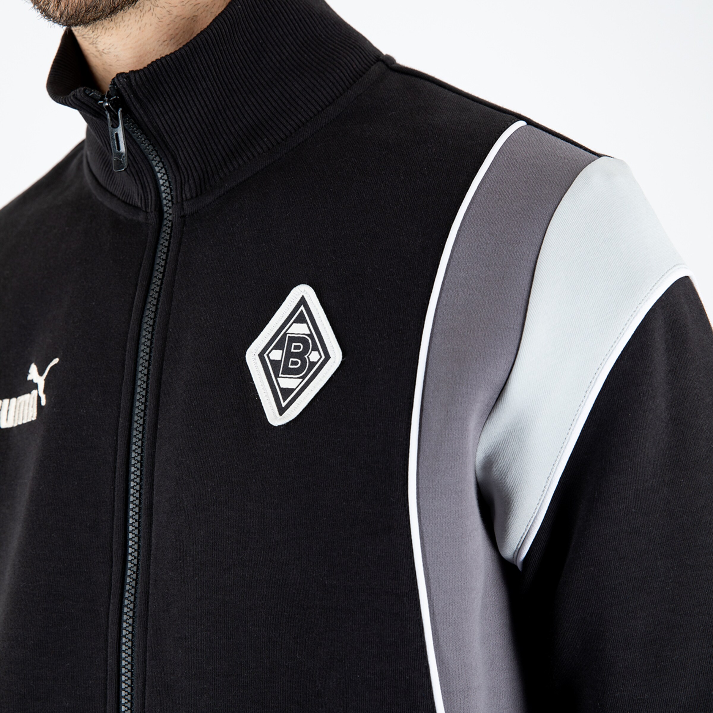 Schwarz-weiße Sportjacke mit dem Borussia Mönchengladbach-Logo und grauen Akzenten.