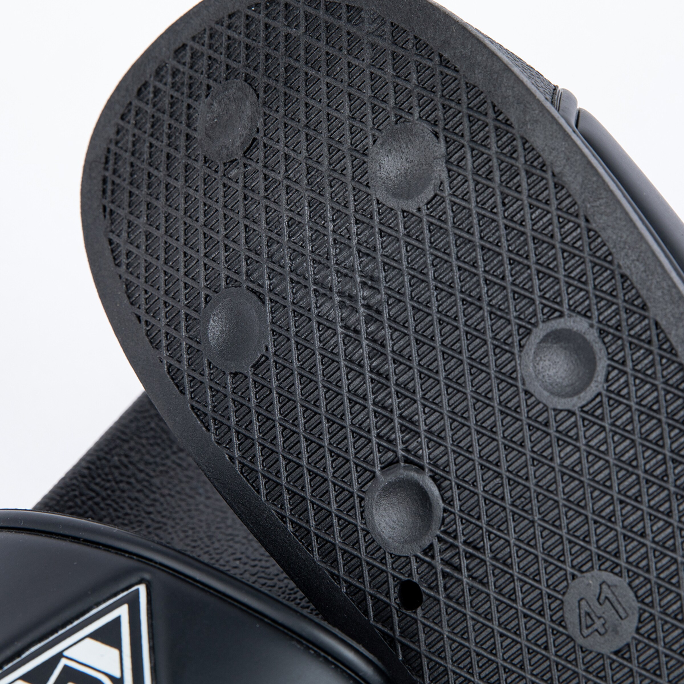 Sohle eines schwarzen Sandalen mit Gummidämpfung und rutschfester Oberfläche.