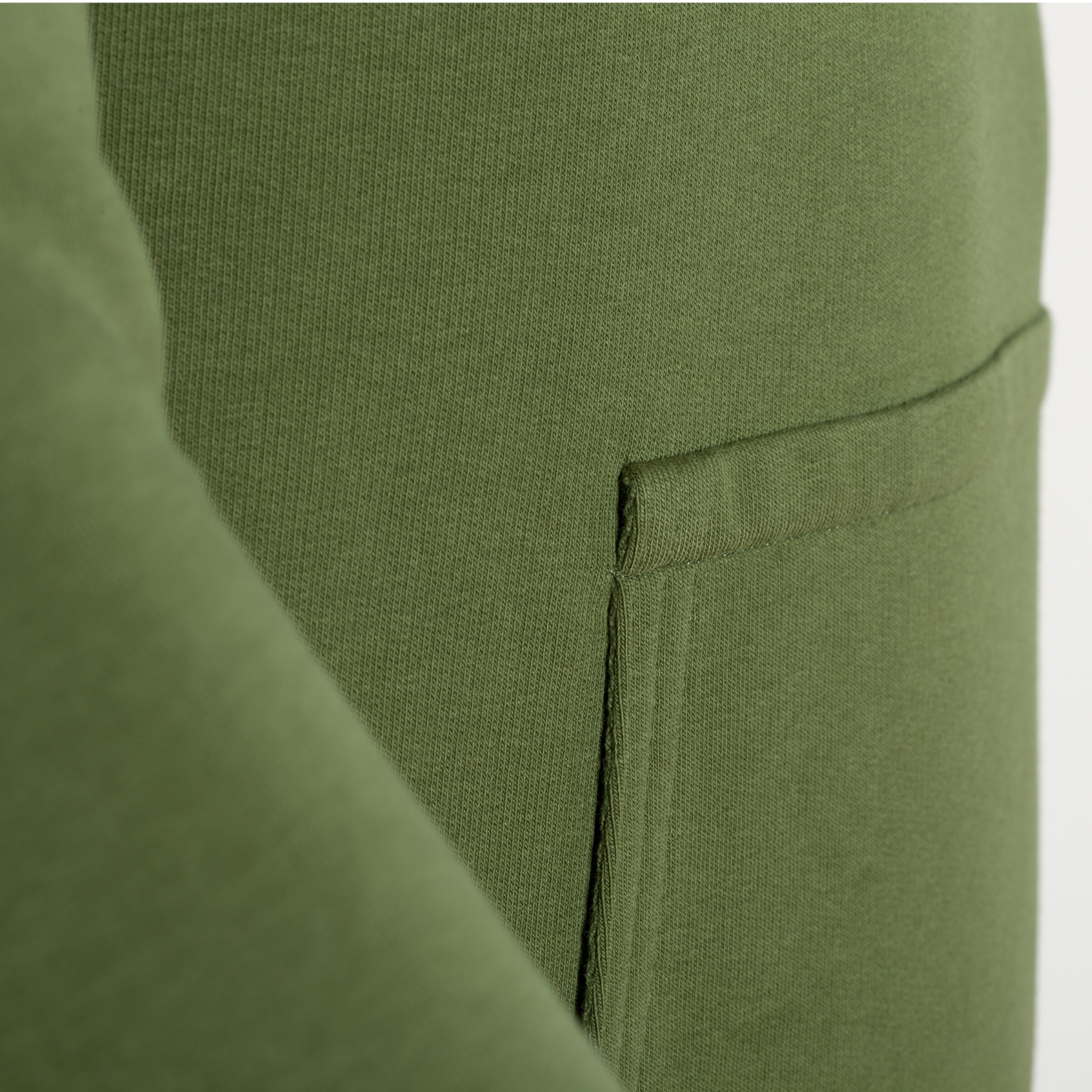 Näheraufnahme einer grünen Hose mit einer Seitentasche.