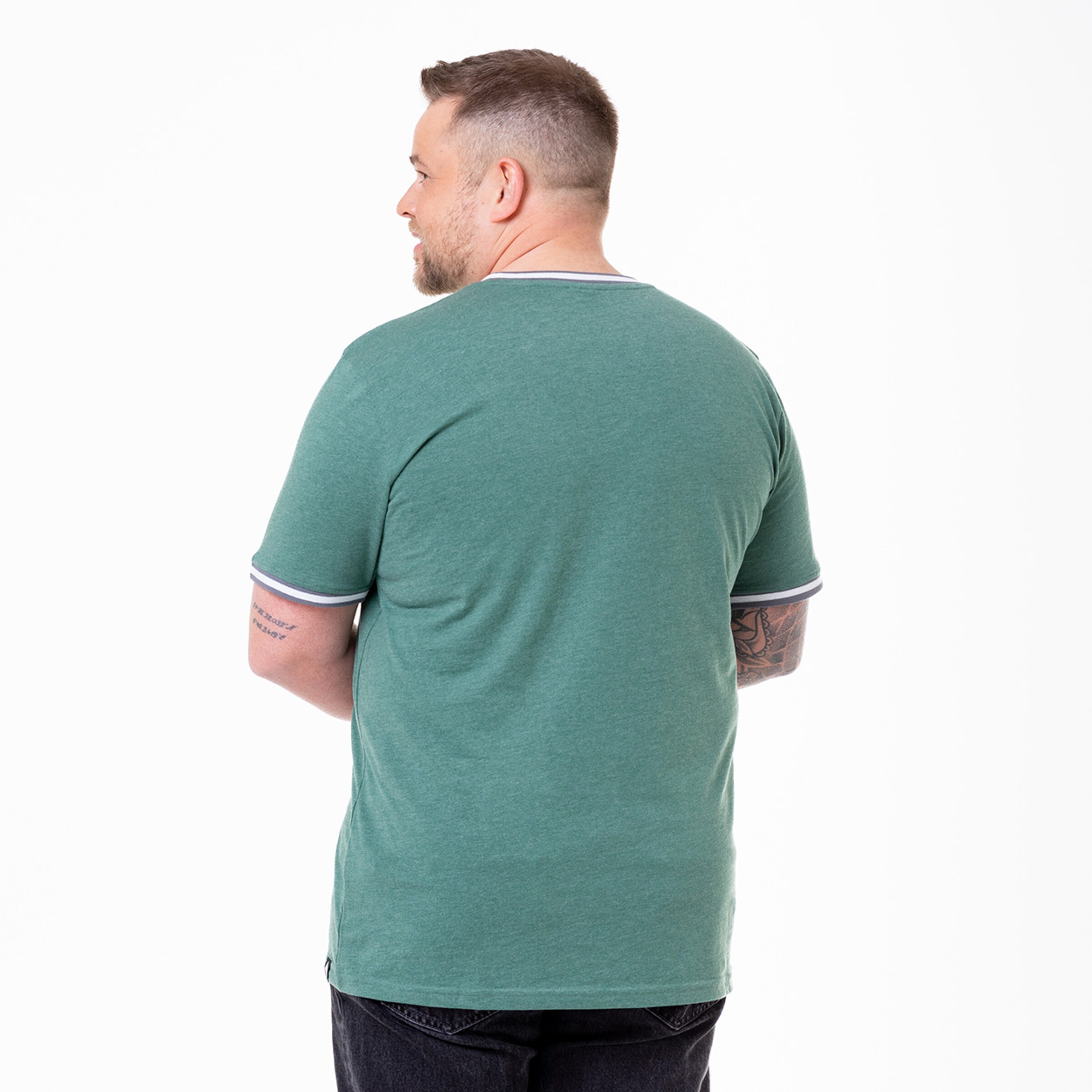Man wearing a short-sleeve green t-shirt photographed from the back.