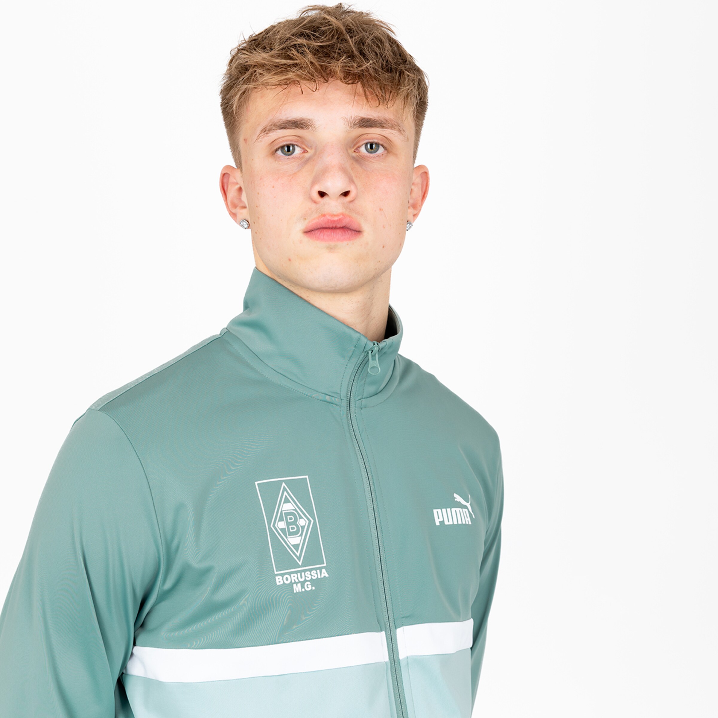 Young person in green Puma jacket with Borussia Mönchengladbach logo.