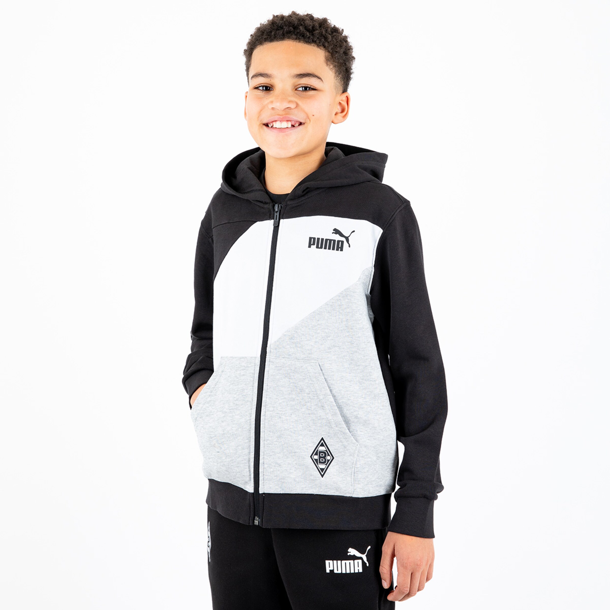 Boy wearing a gray and black Puma jacket featuring Borussia Mönchengladbach logo.