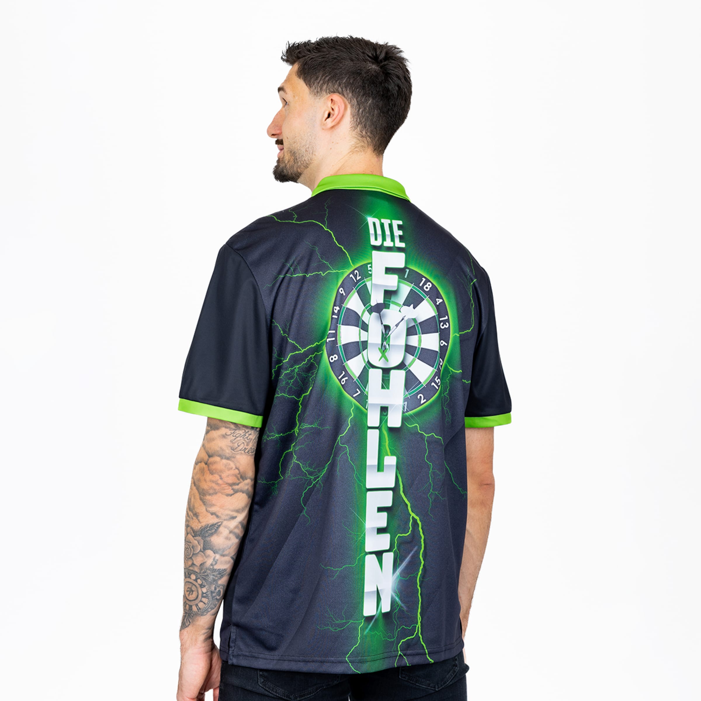 Rückansicht eines Mannes im dunklen Poloshirt mit neongrünem „DIE FOHLEN“-Schriftzug, Dartscheibe und Blitz-Motiv auf dem Rücken.