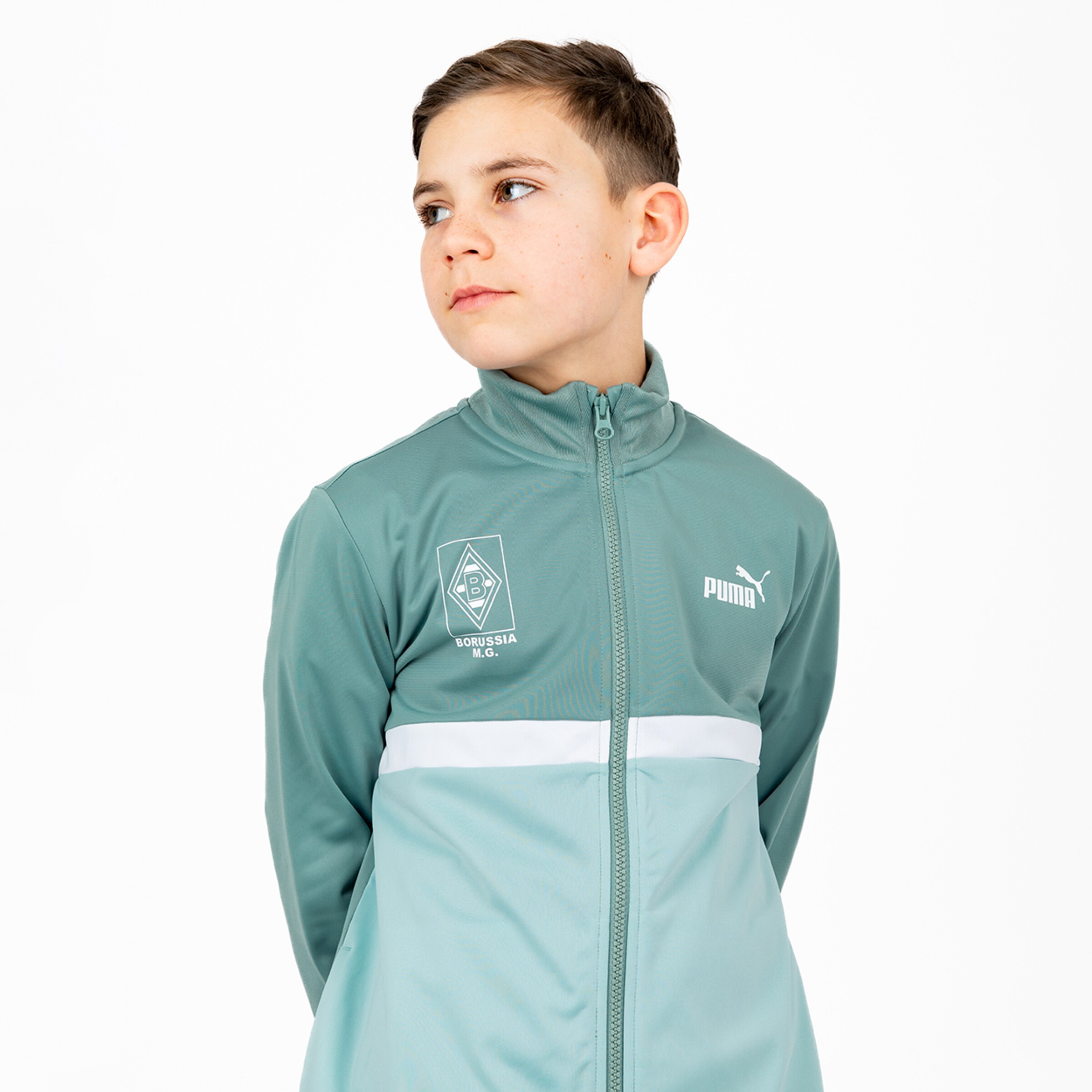 Junge in einem hellen Trainingsanzug von Borussia Mönchengladbach.