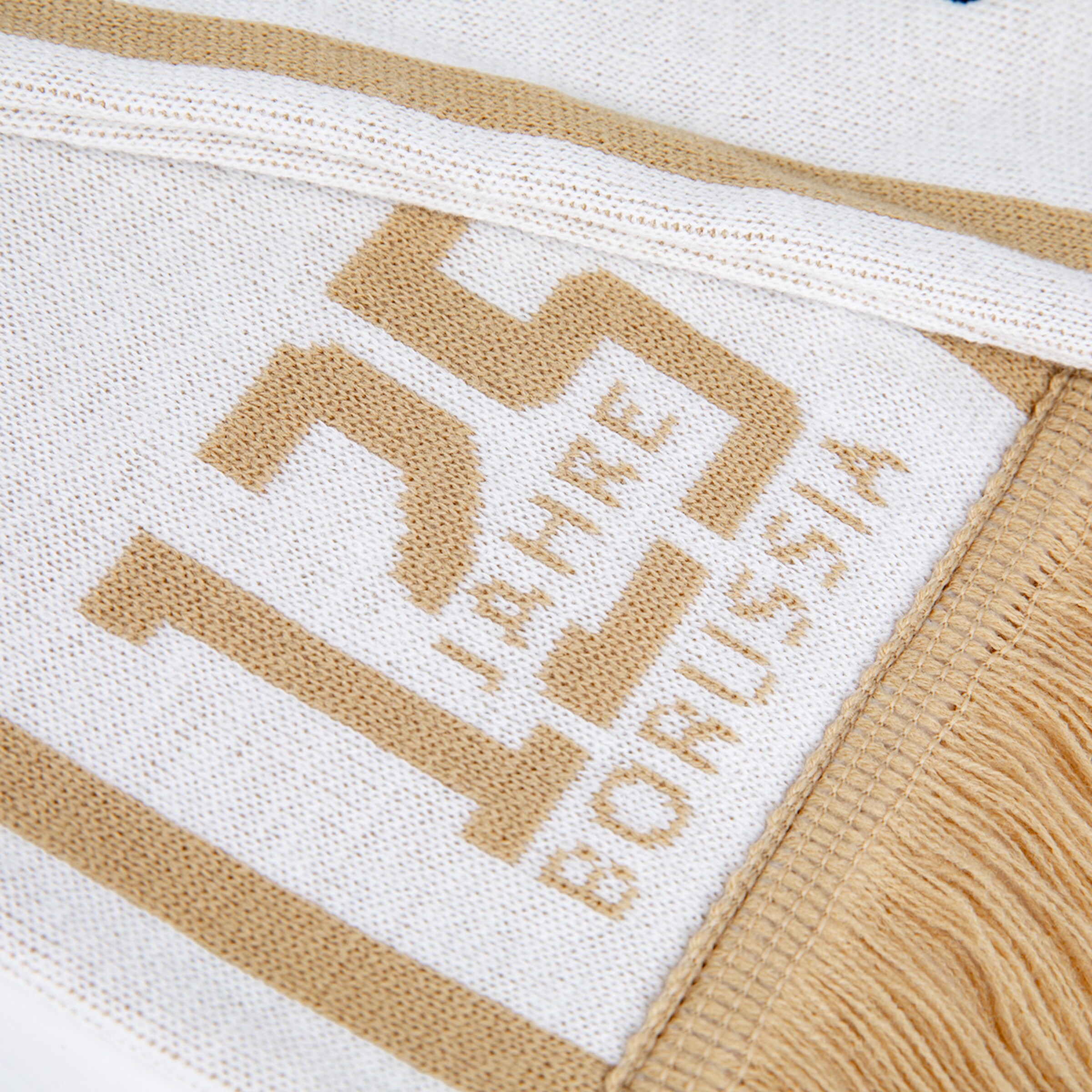 Nahaufnahme eines weiß-goldenen Strickschals mit großen Ziffern „125“ sowie dem Text „JAHRE BORUSSIA“ und Fransen.