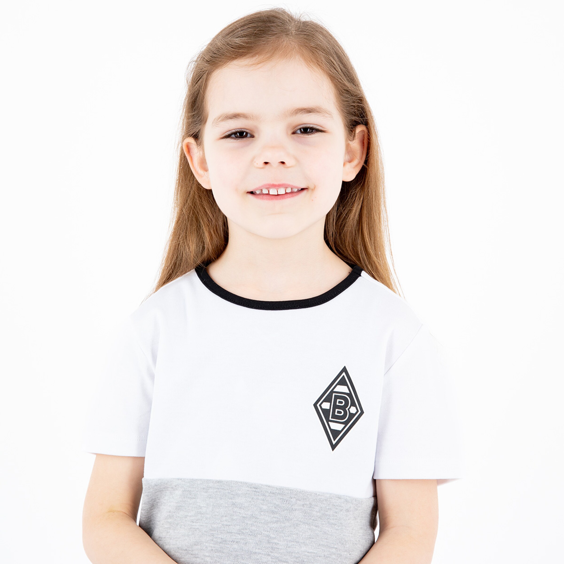 Ein Mädchen mit langen braunen Haaren in einem weißen und grauen T-Shirt mit dem Borussia Mönchengladbach-Logo.
