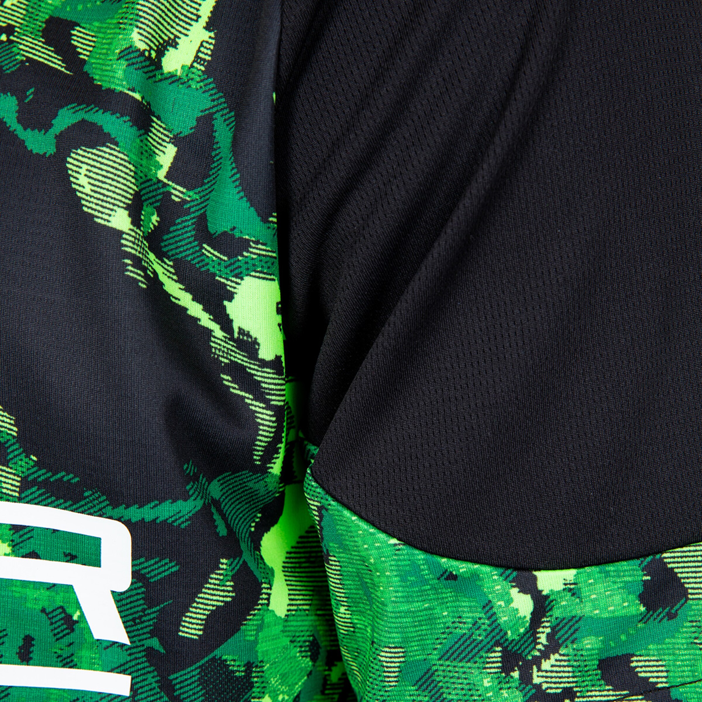 Nahaufnahme eines sportlichen Trikots mit grünem und schwarzem Muster.