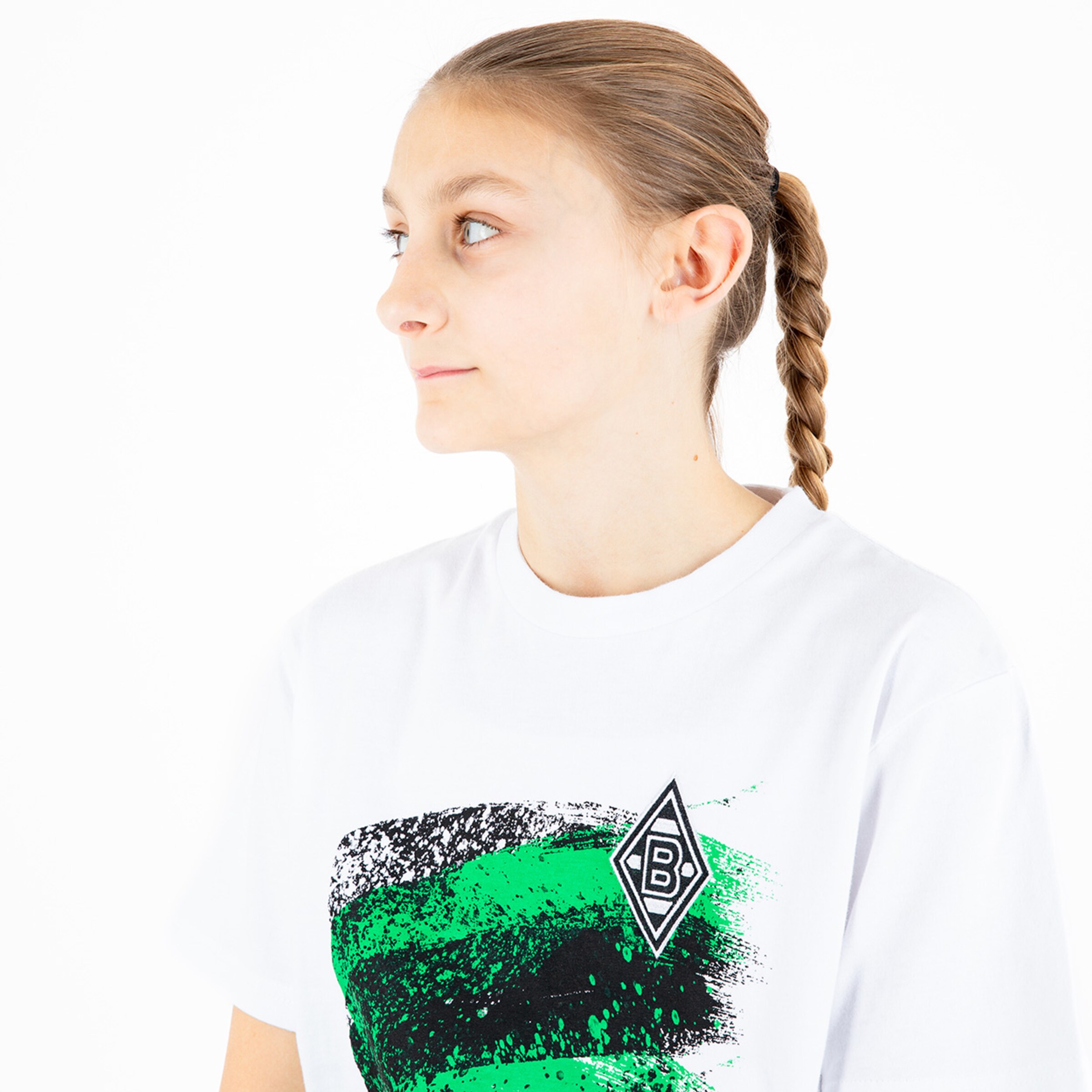 Girl with braided hair wearing a white t-shirt featuring a green and black design and Borussia Mönchengladbach logo.