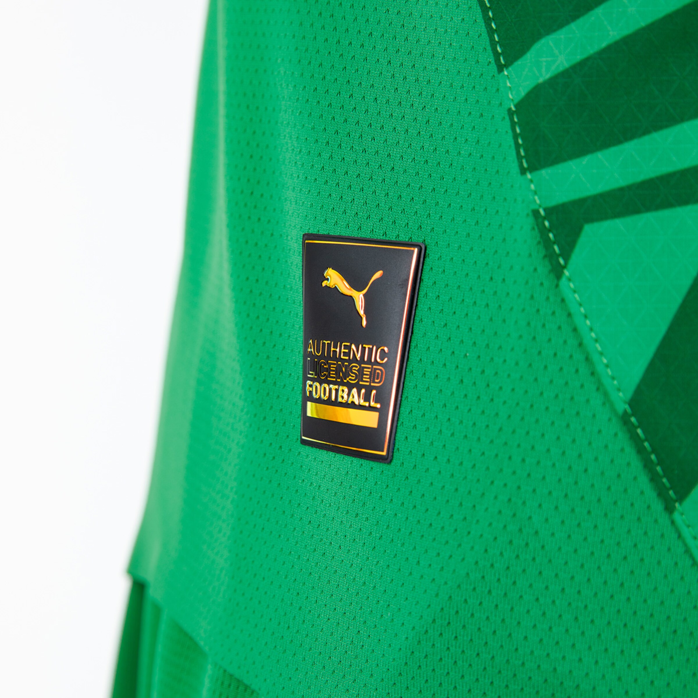Green jersey featuring a black PUMA label for authentic licenses.