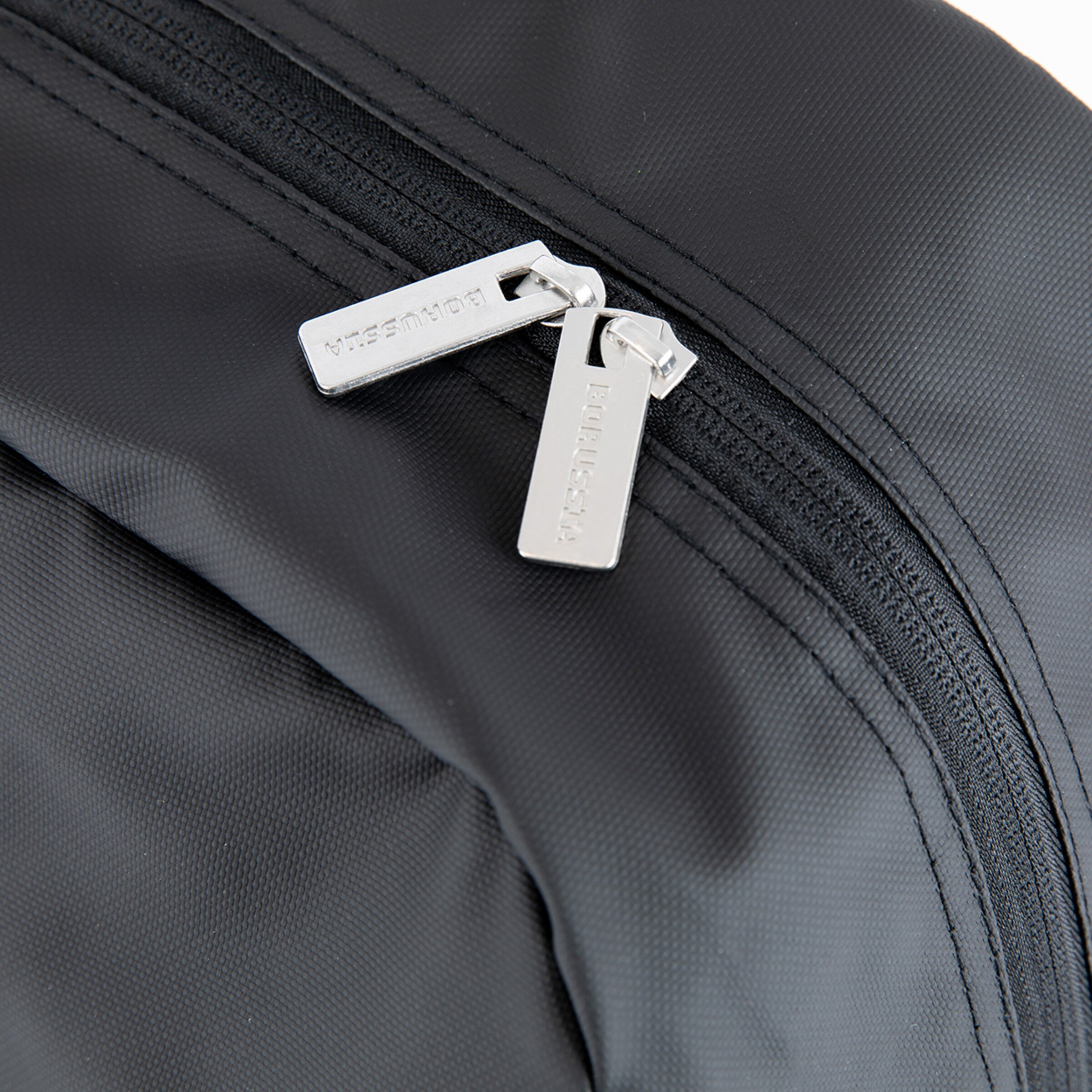 Schwarze Tasche mit silbernen Reißverschlüssen die einen Markenaufdruck zeigen.