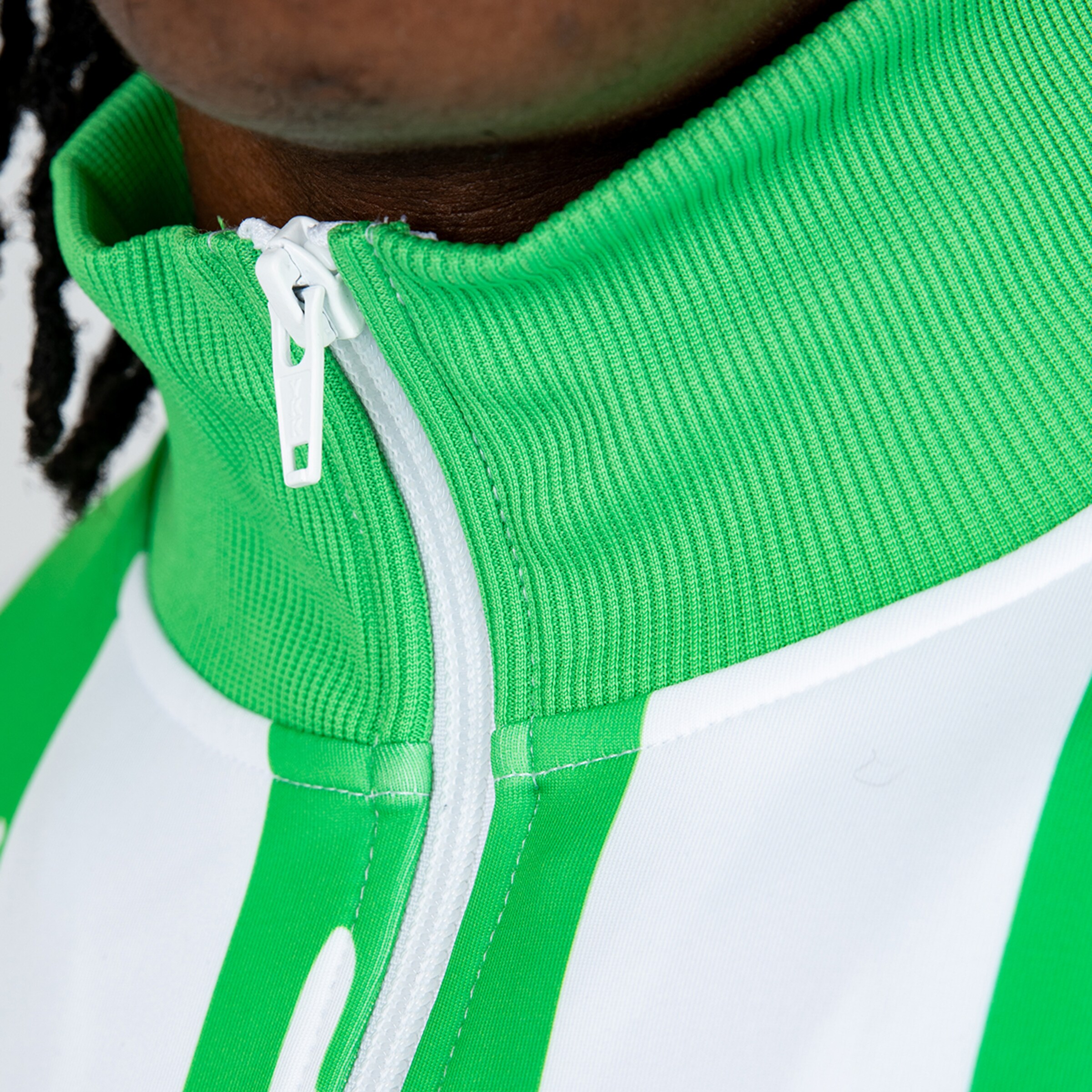 Close-up of a green and white training suit featuring a stand-up collar and zipper.