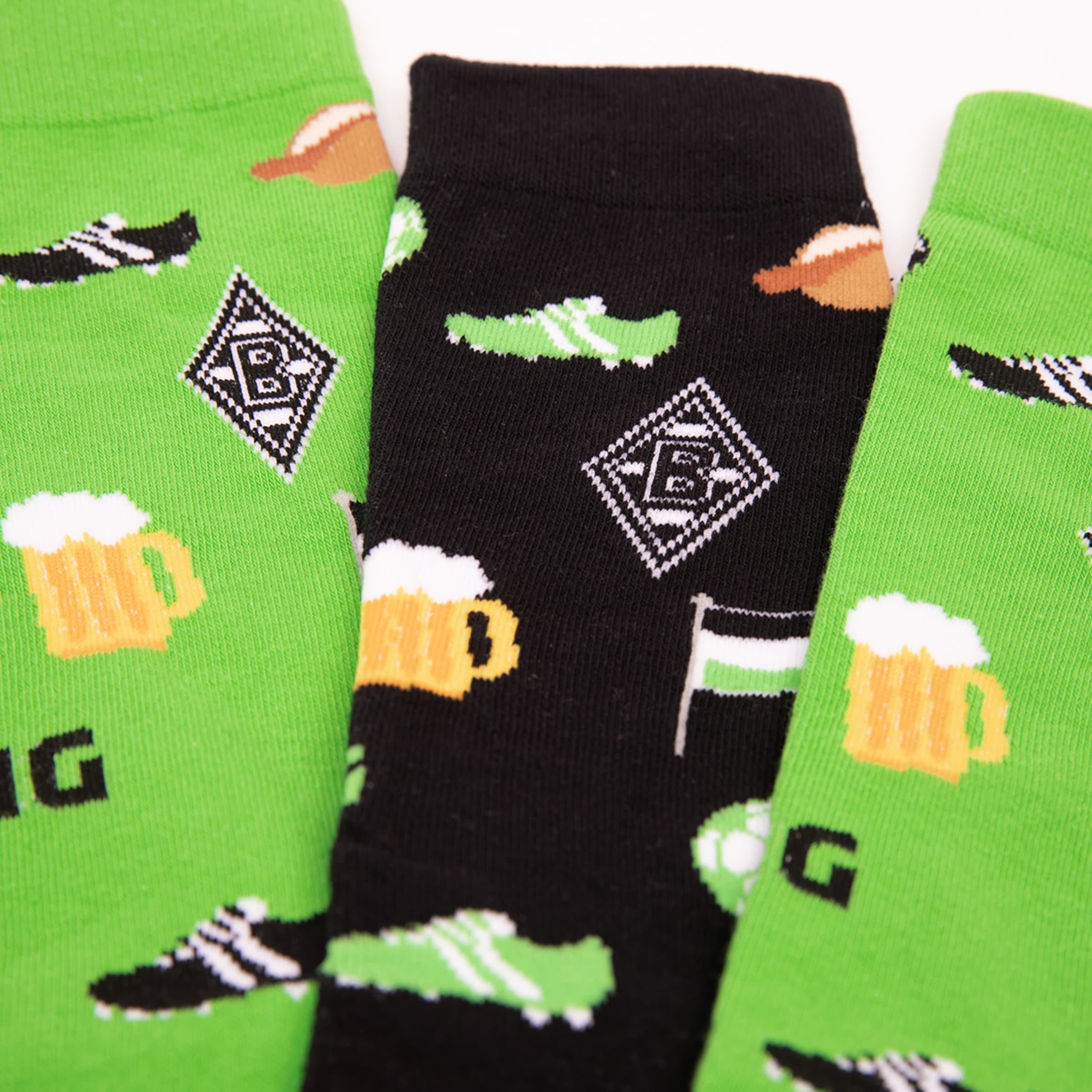 Three pairs of socks featuring football and beer motifs along with the Borussia Mönchengladbach logo.
