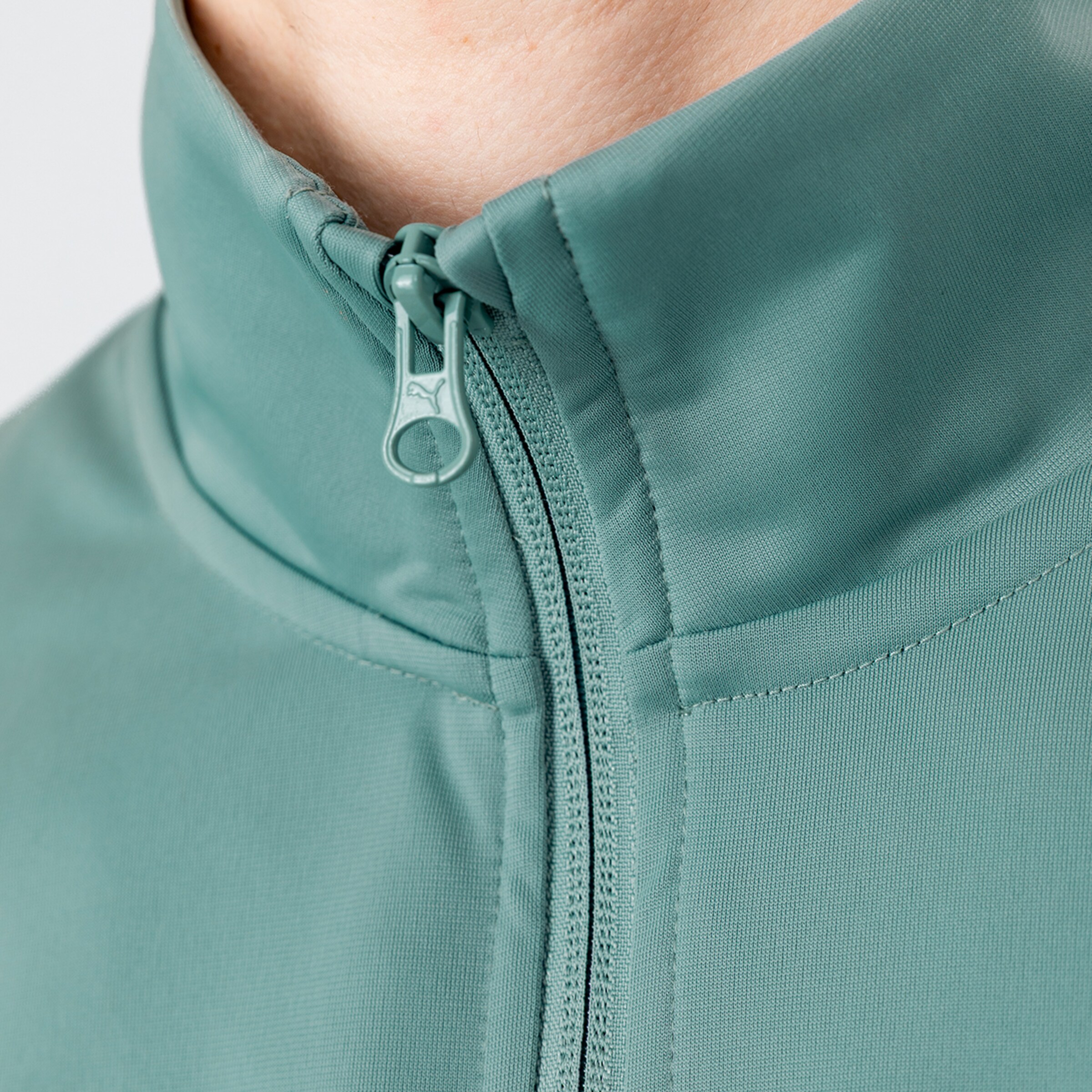 Close-up of the collar and zipper of a green sports jacket.