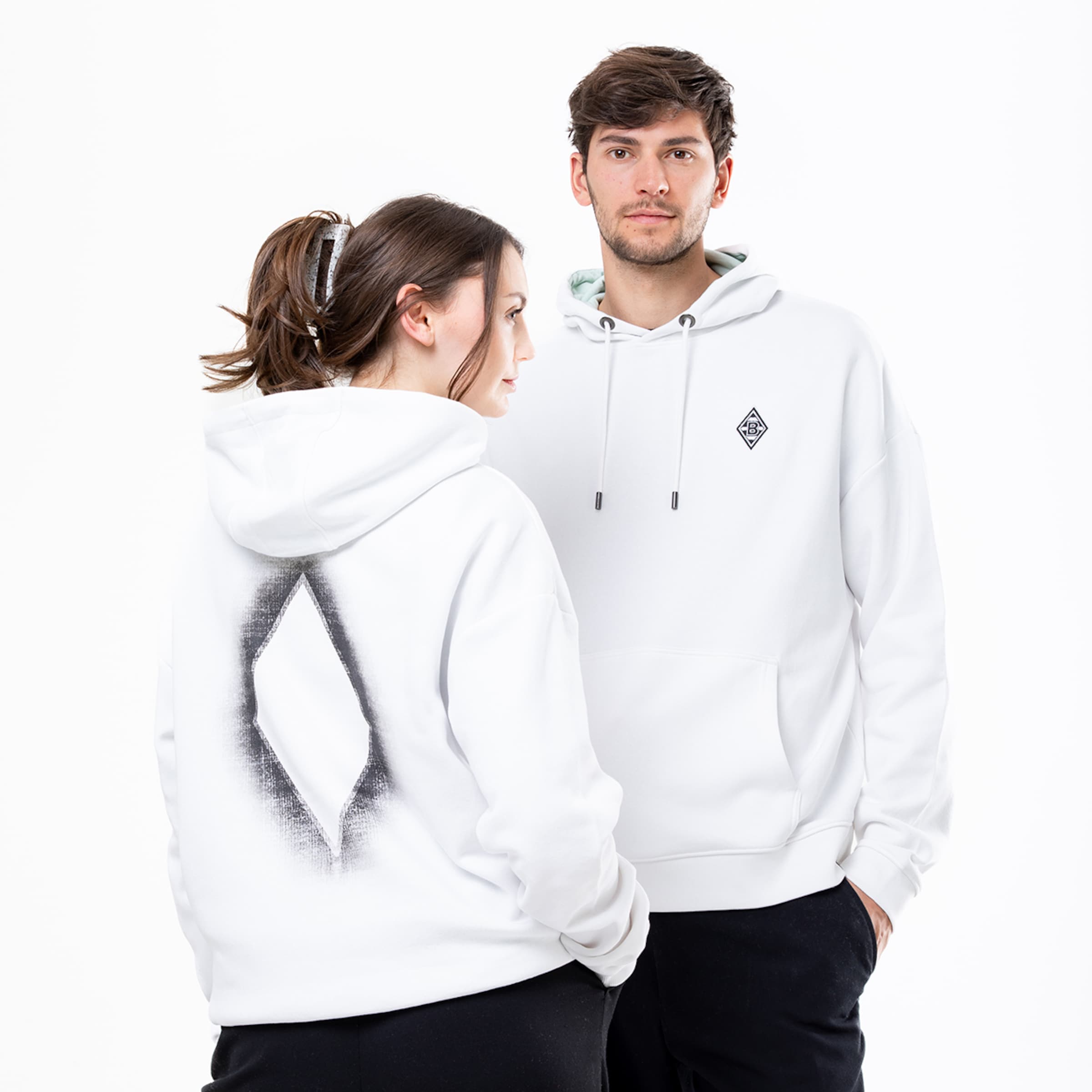 Modelle präsentieren weiße Hoodies mit grafischen Designs.
