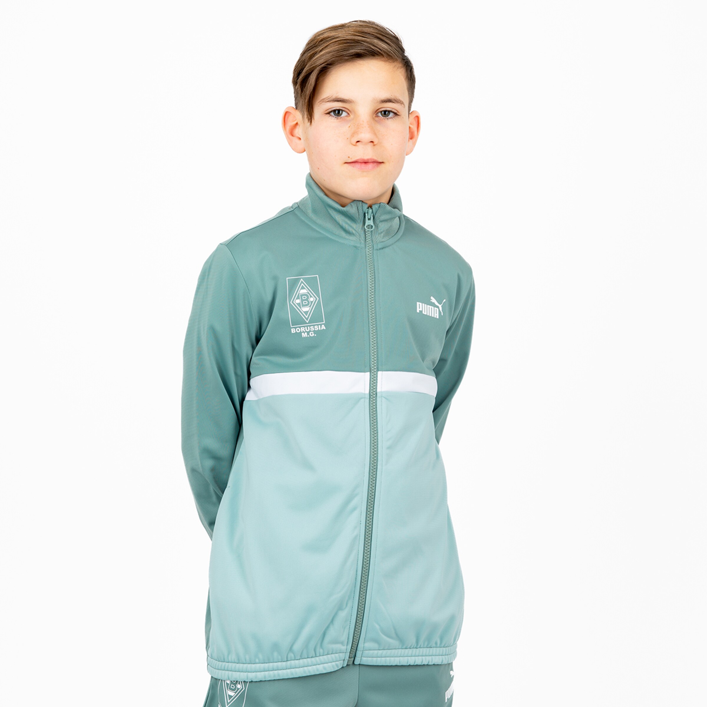 Ein junger Spieler in einer sportlichen Jacke von Puma mit Borussia Mönchengladbach Logo.