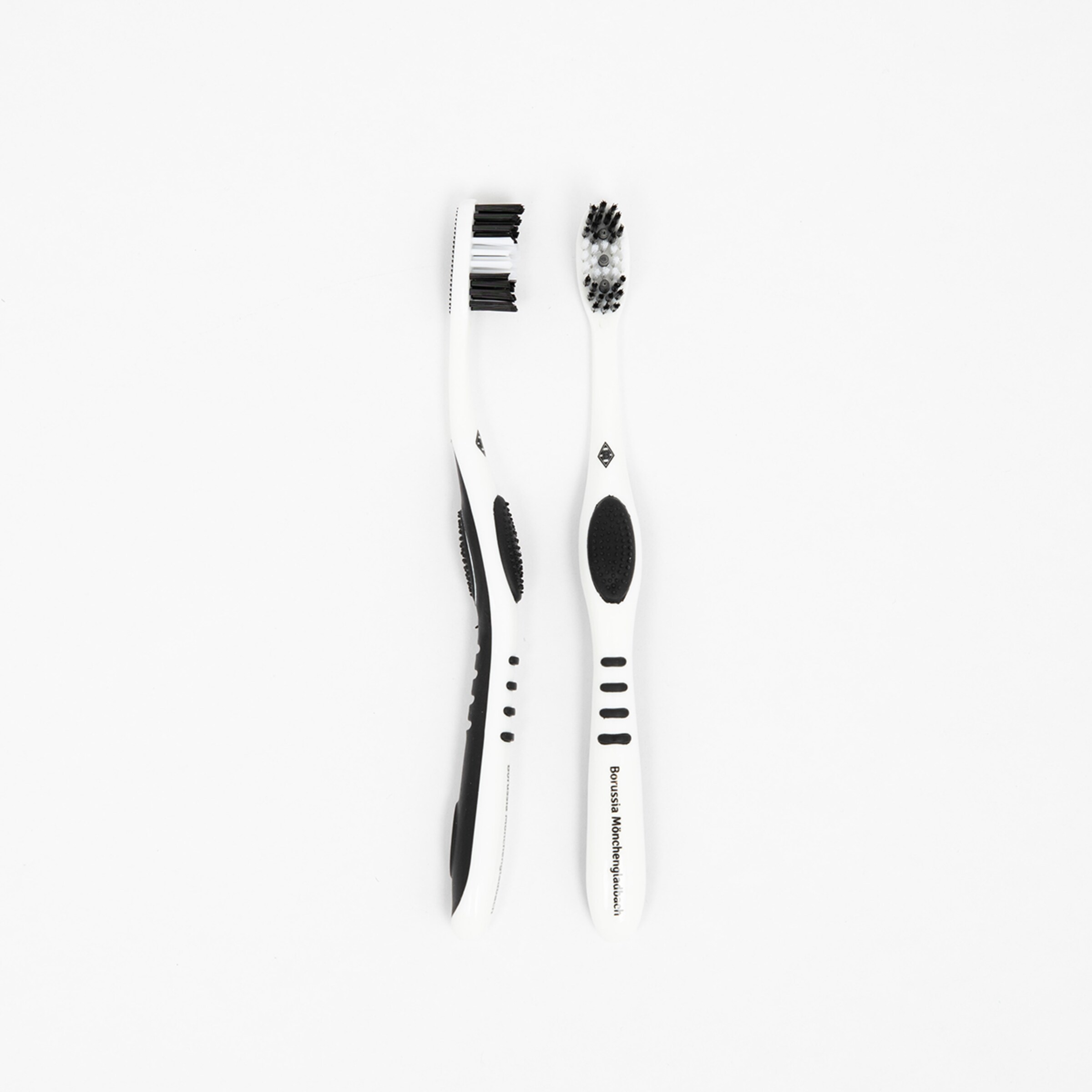 Two white toothbrushes with black grips one has hard bristles and the other has soft bristles.