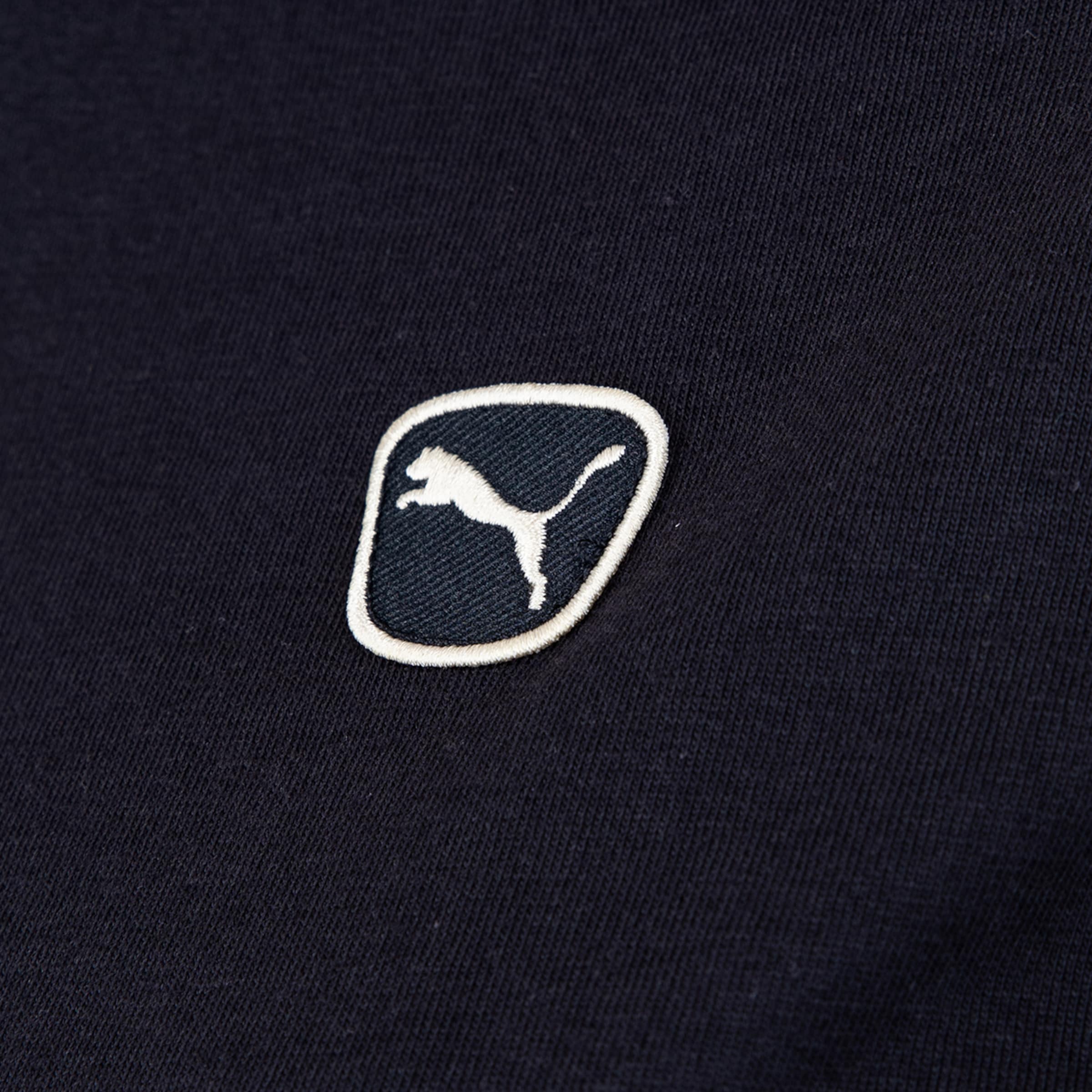 Nahaufnahme eines schwarz-weißen Puma-Logo-Aufnähers auf dunklem Stoff. Der Aufnäher zeigt die charakteristische springende Raubkatze.