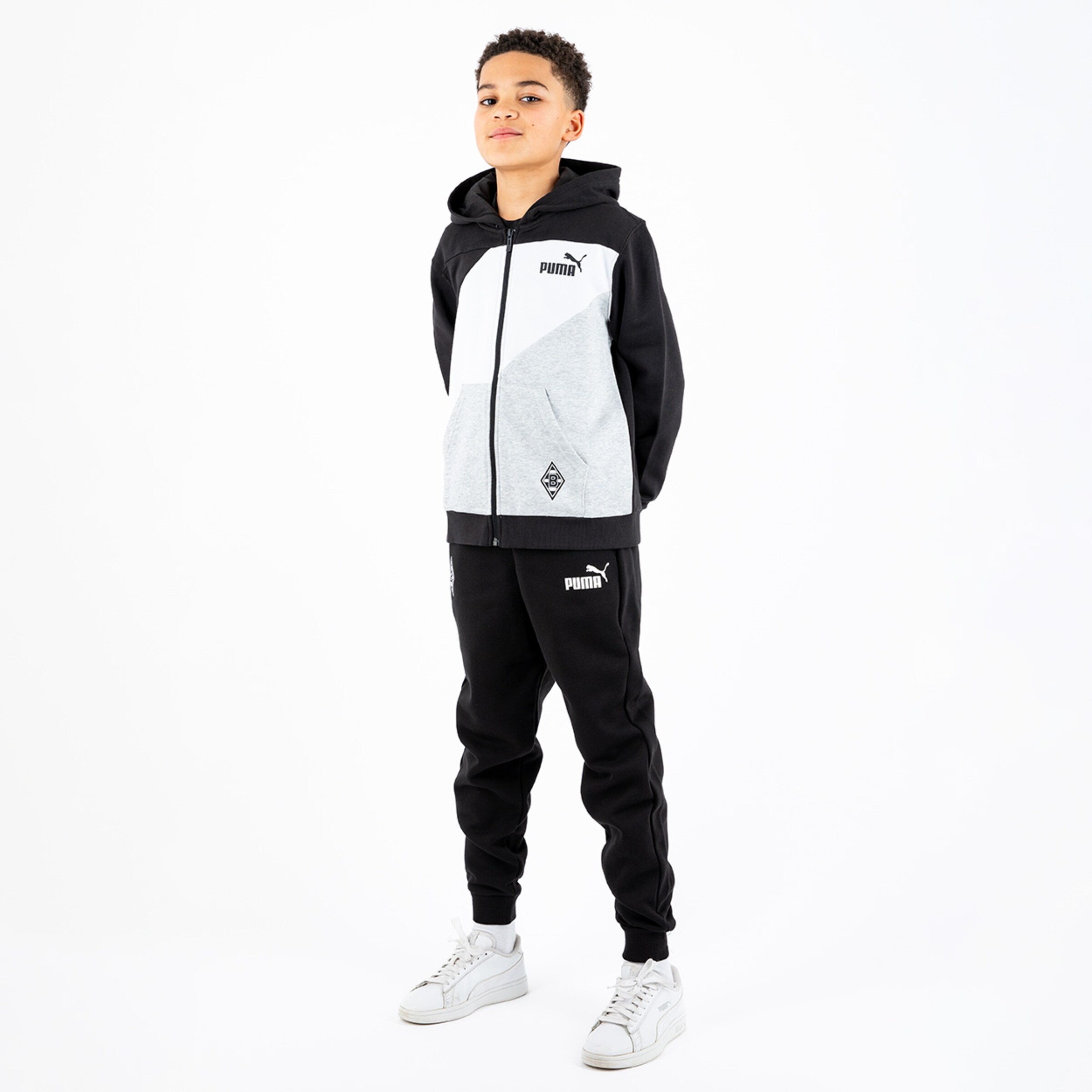 Boy wearing a grey and black tracksuit from Puma featuring Borussia Mönchengladbach logo.