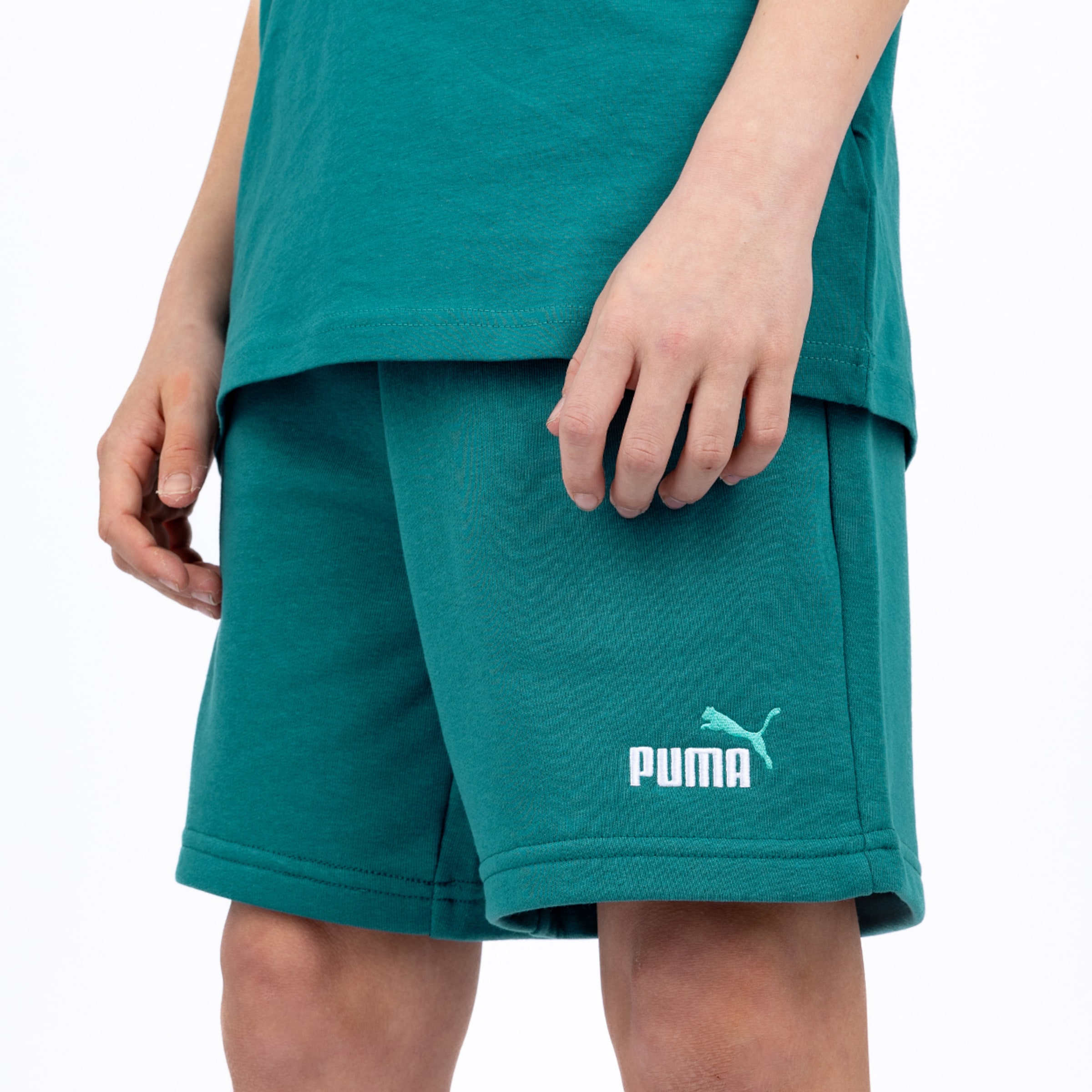Person wearing dark green Puma shorts and a matching t-shirt. The white Puma logo is featured on the leg of the shorts.