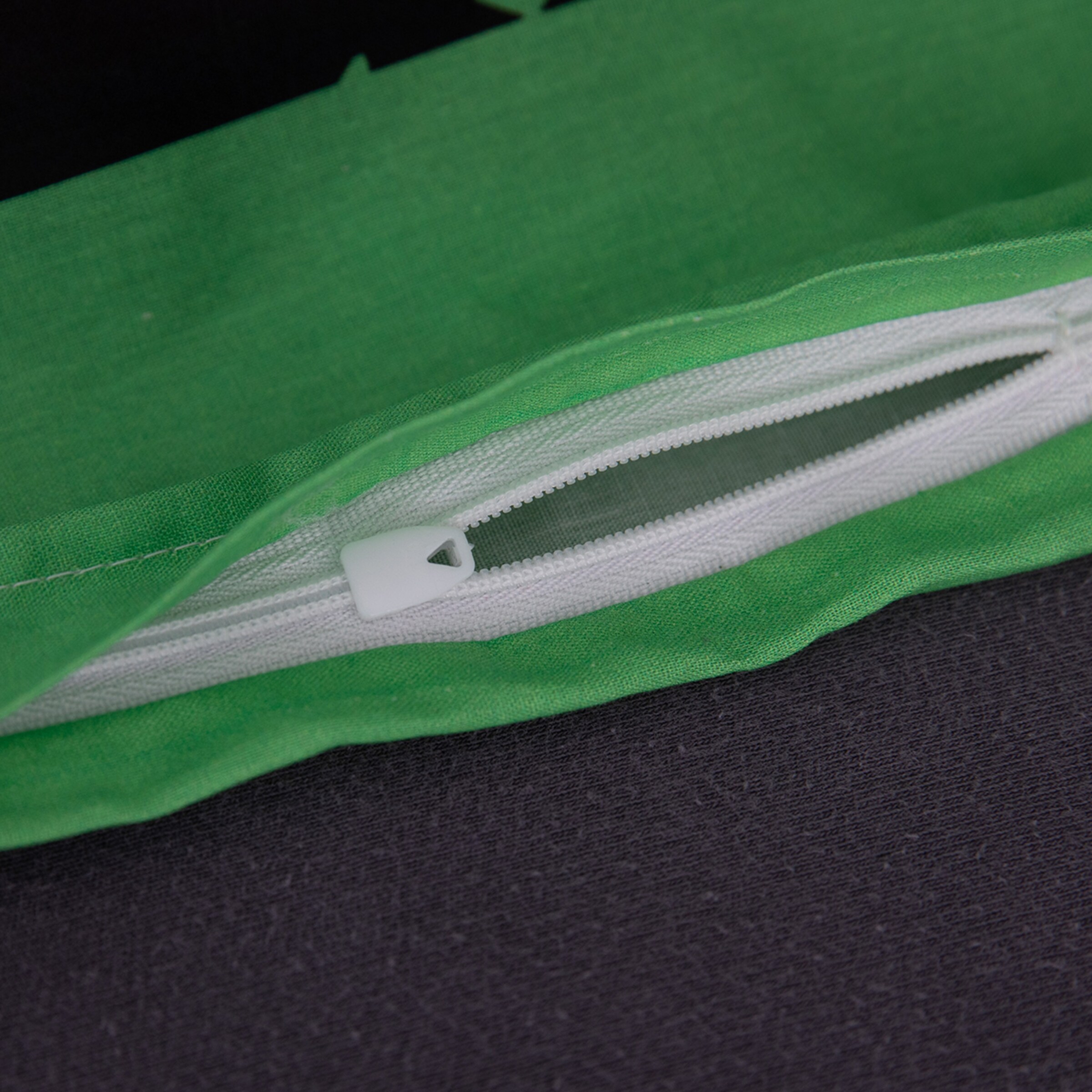 Grüner Stoff mit Reißverschluss der geöffnet ist.