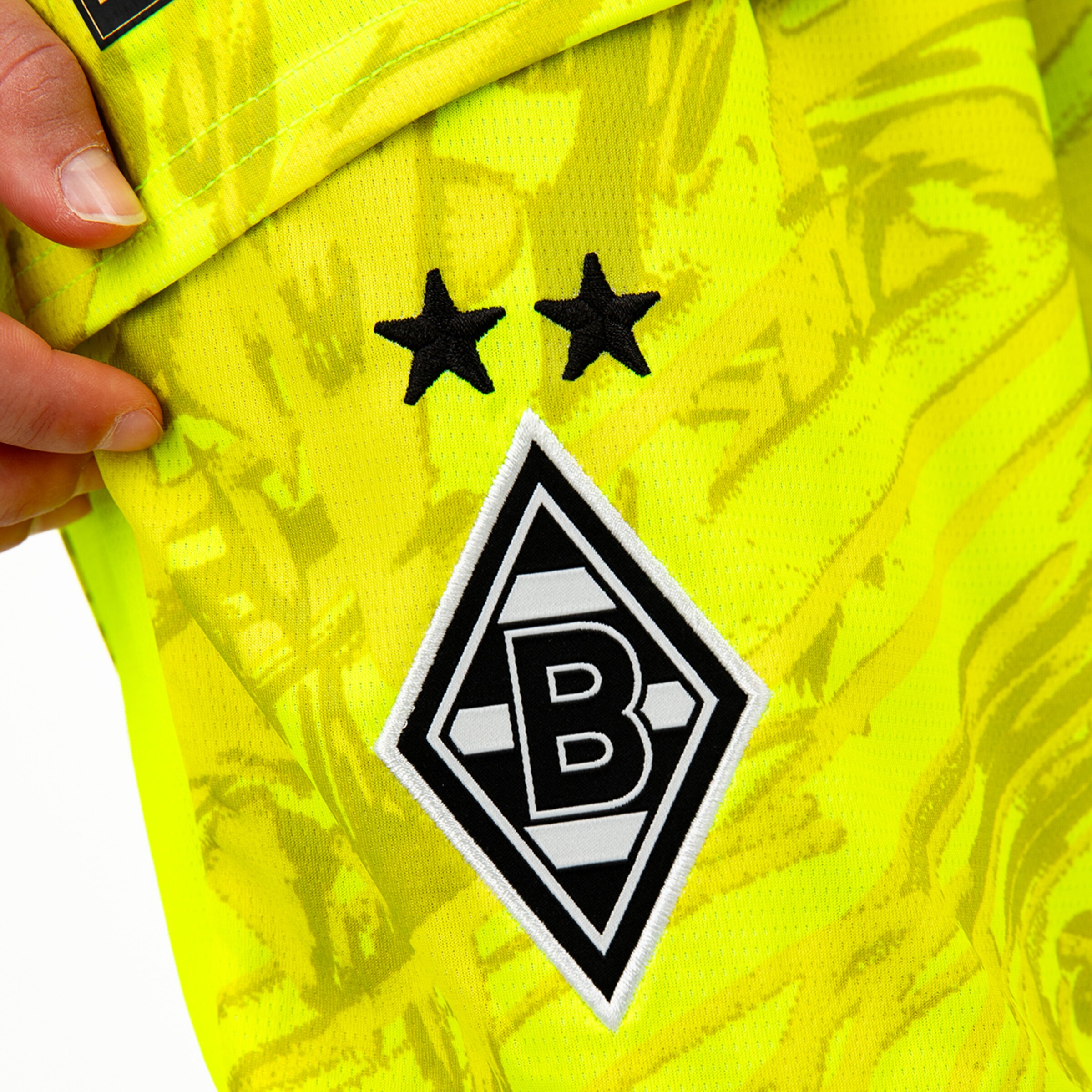 Auschnitt eines Trikots mit dem Borussia Mönchengladbach-Logo und zwei Sternen.