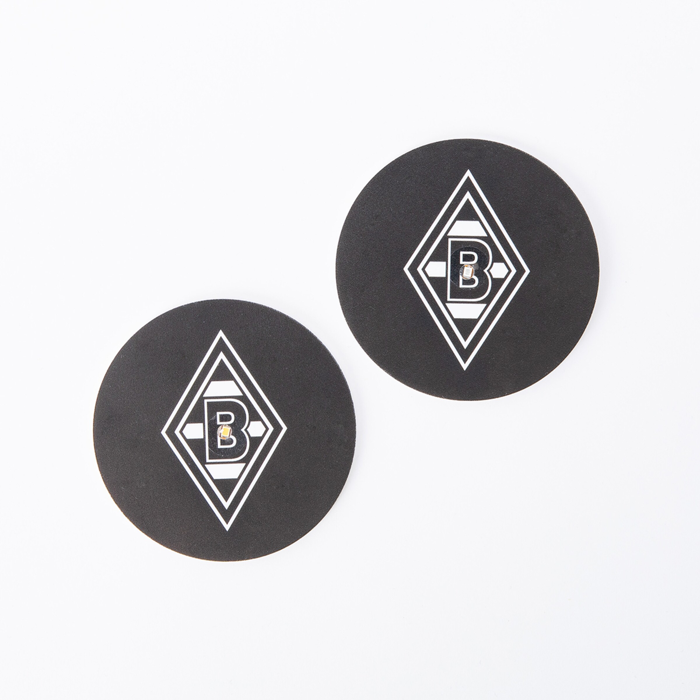 Zwei runde schwarze Untersetzer mit dem Borussia Mönchengladbach-Logo.
