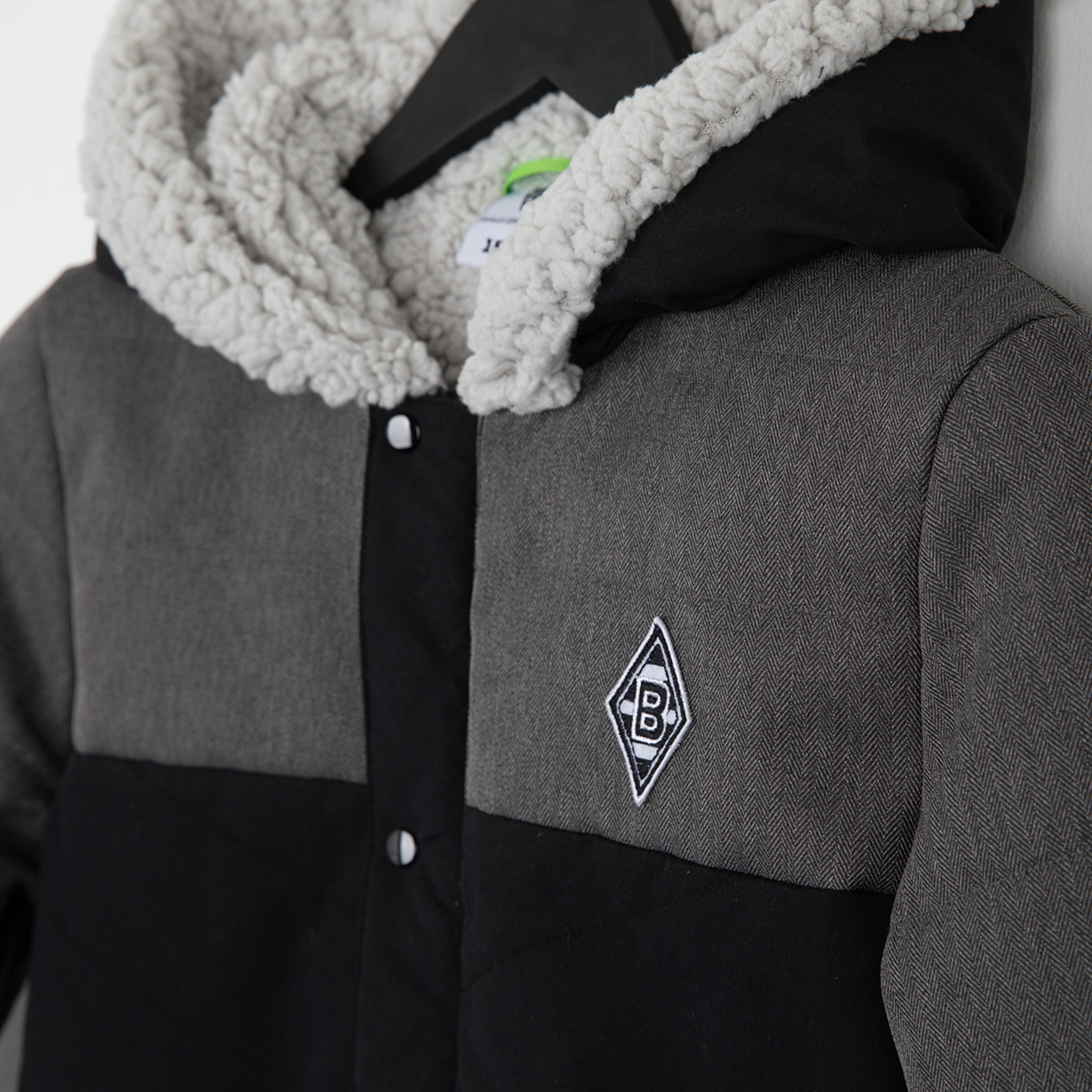 Black and gray jacket featuring a white Borussia Mönchengladbach emblem.