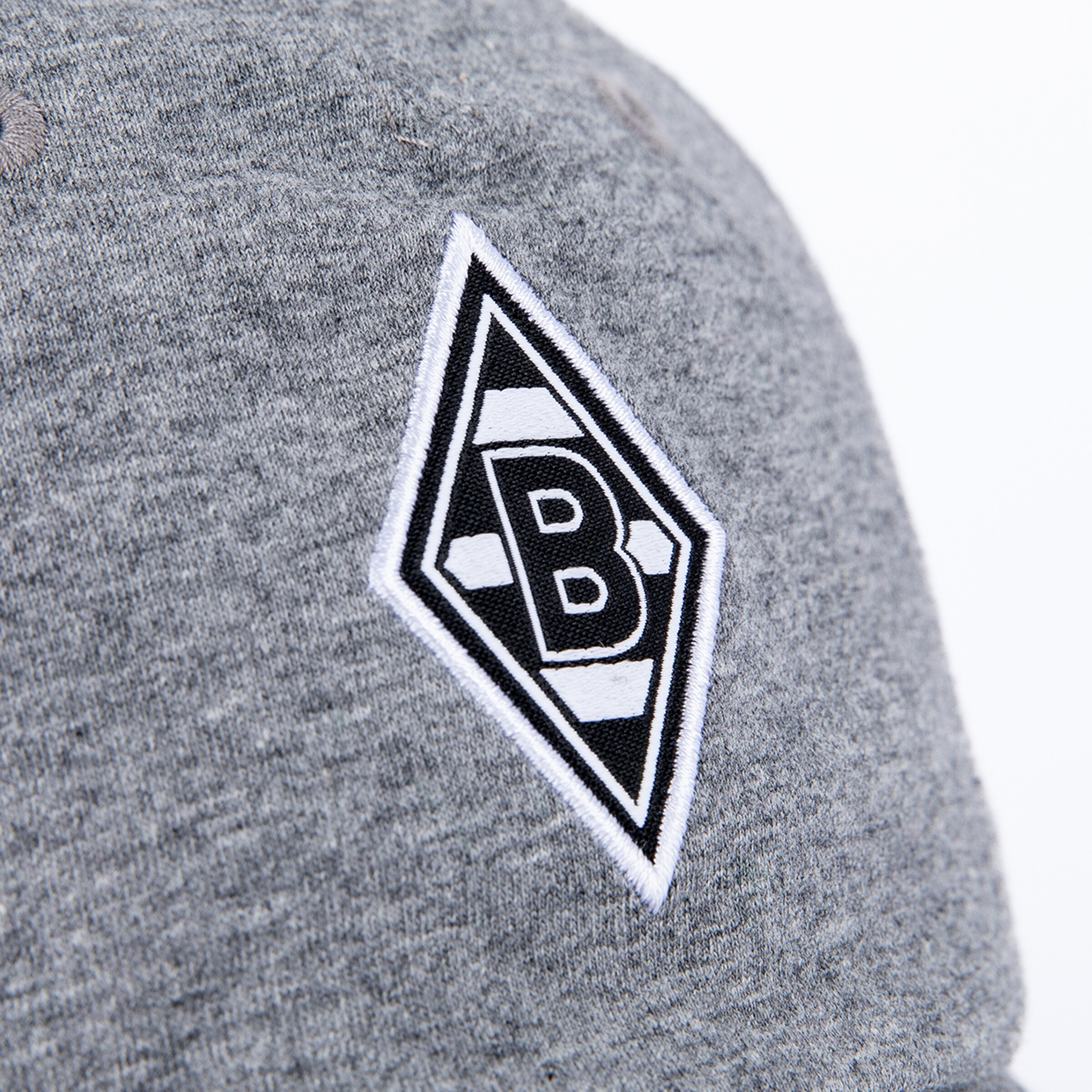Nahaufnahme einer meliert grauen Kappe mit einem bestickten schwarzen Rautenlogo, das ein weißes „B“ und eine weiße Umrandung zeigt.