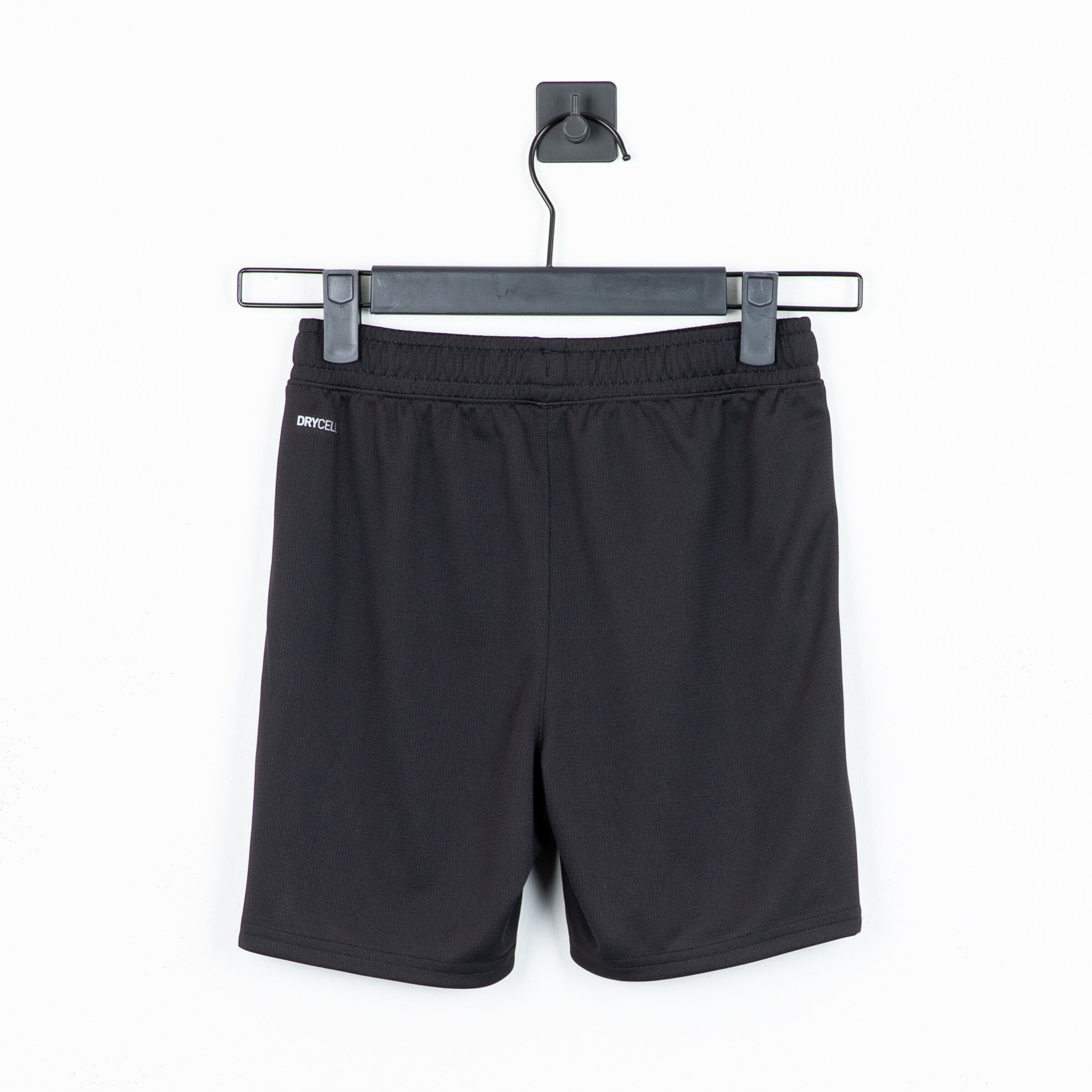 Black sports shorts with an elastic waistband hanging on a clothes hanger.