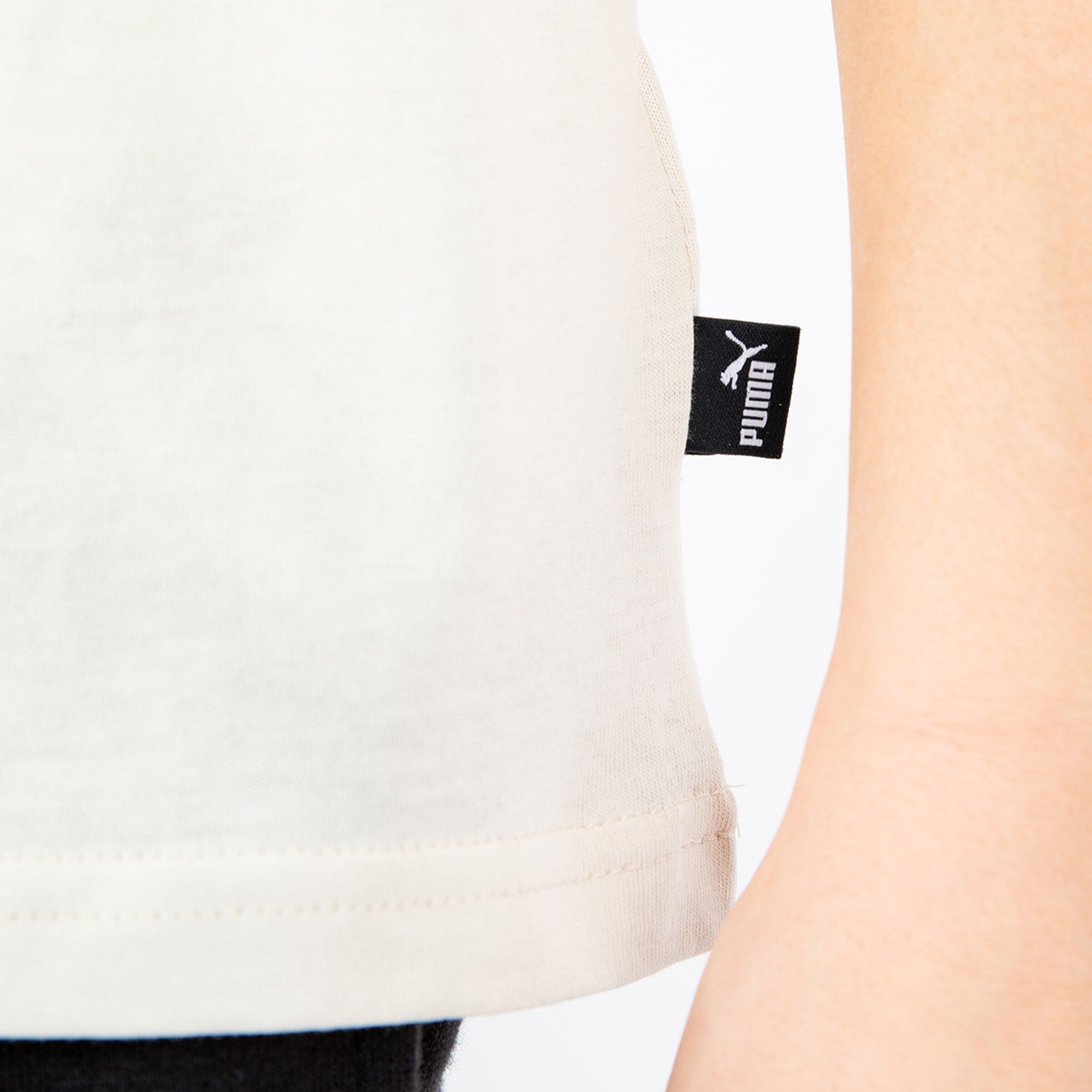 Detailaufnahme eines weißen Shirts mit Puma-Logo.