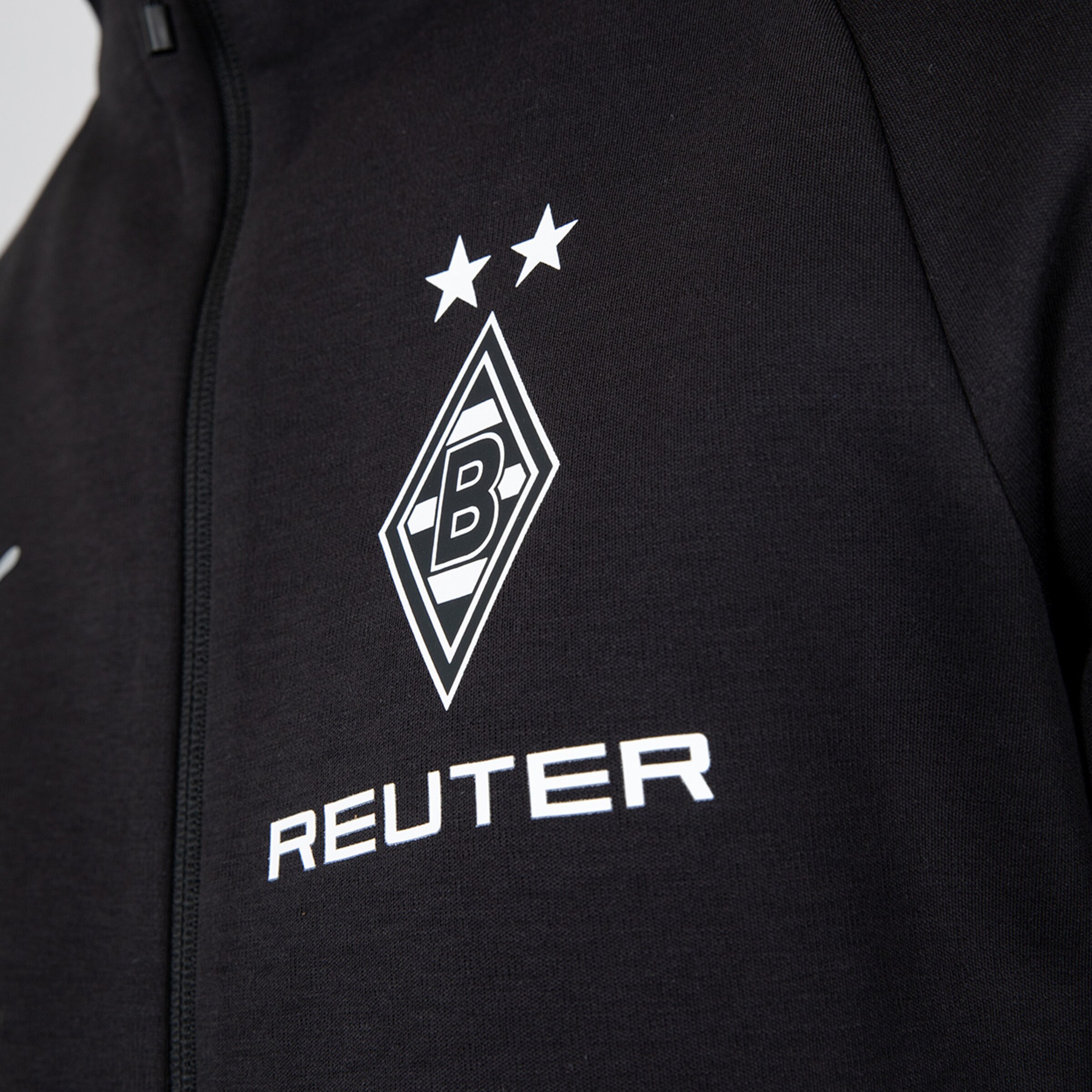 Schwarze Jacke mit dem Borussia Mönchengladbach Logo und dem Text ‚REUTER‘.