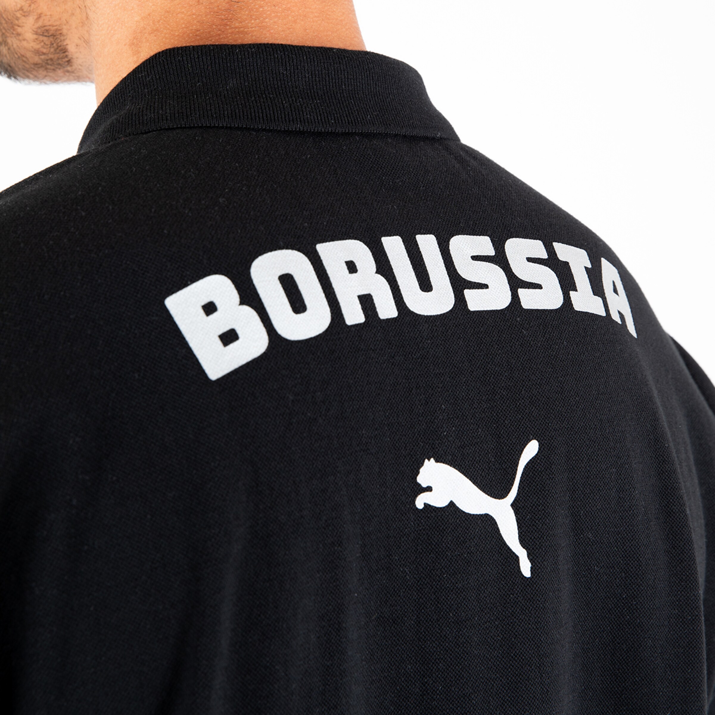 Schwarzes Polo mit dem Schriftzug BORUSSIA auf dem Rücken und dem Puma-Logo.
