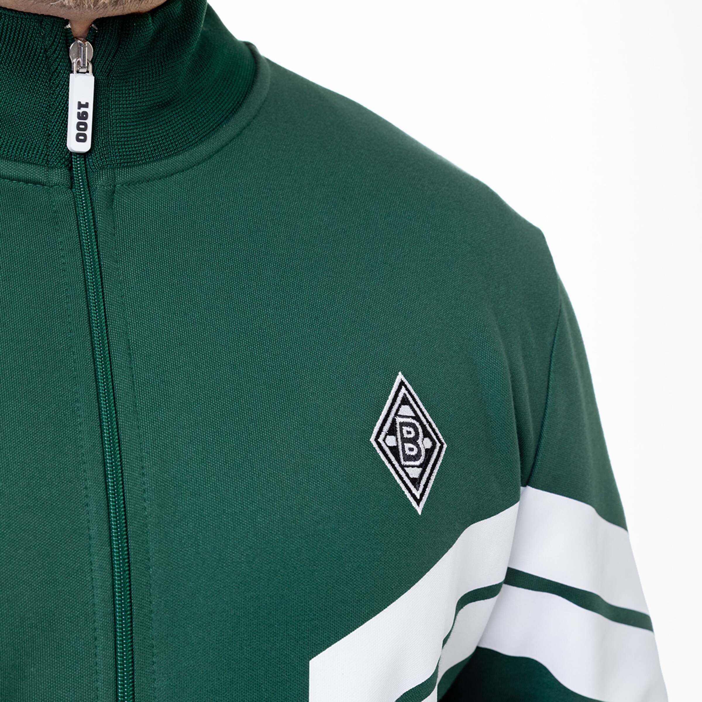 Nahaufnahme eines grünen Trainingsjacke mit Borussia Mönchengladbach-Logo.