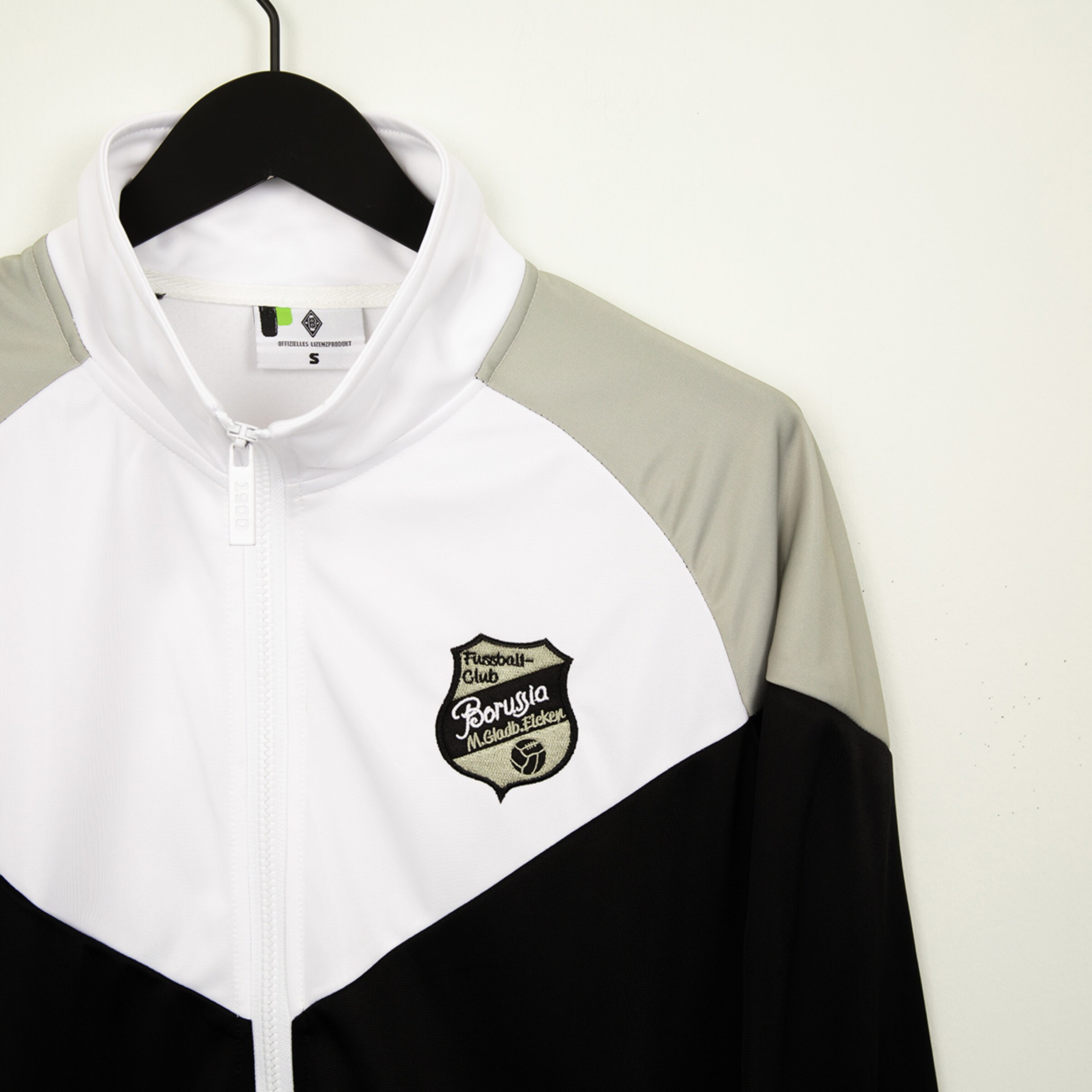 Jacke des Fußballclub Borussia Mönchengladbach mit Logo und Reißverschluss.