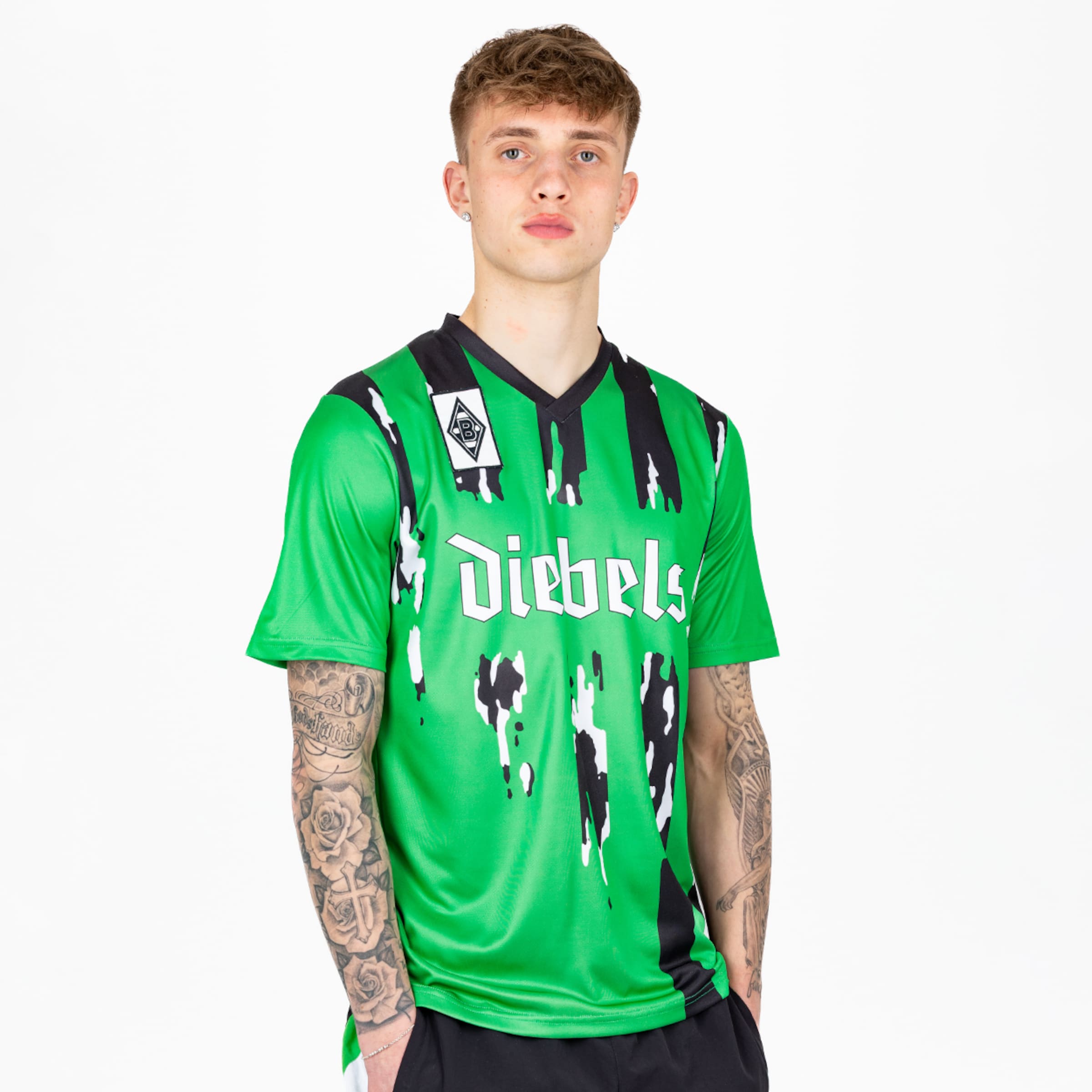 Ein junger Mann trägt das grüne Trikot von Borussia Mönchengladbach mit dem Schriftzug Diebels.