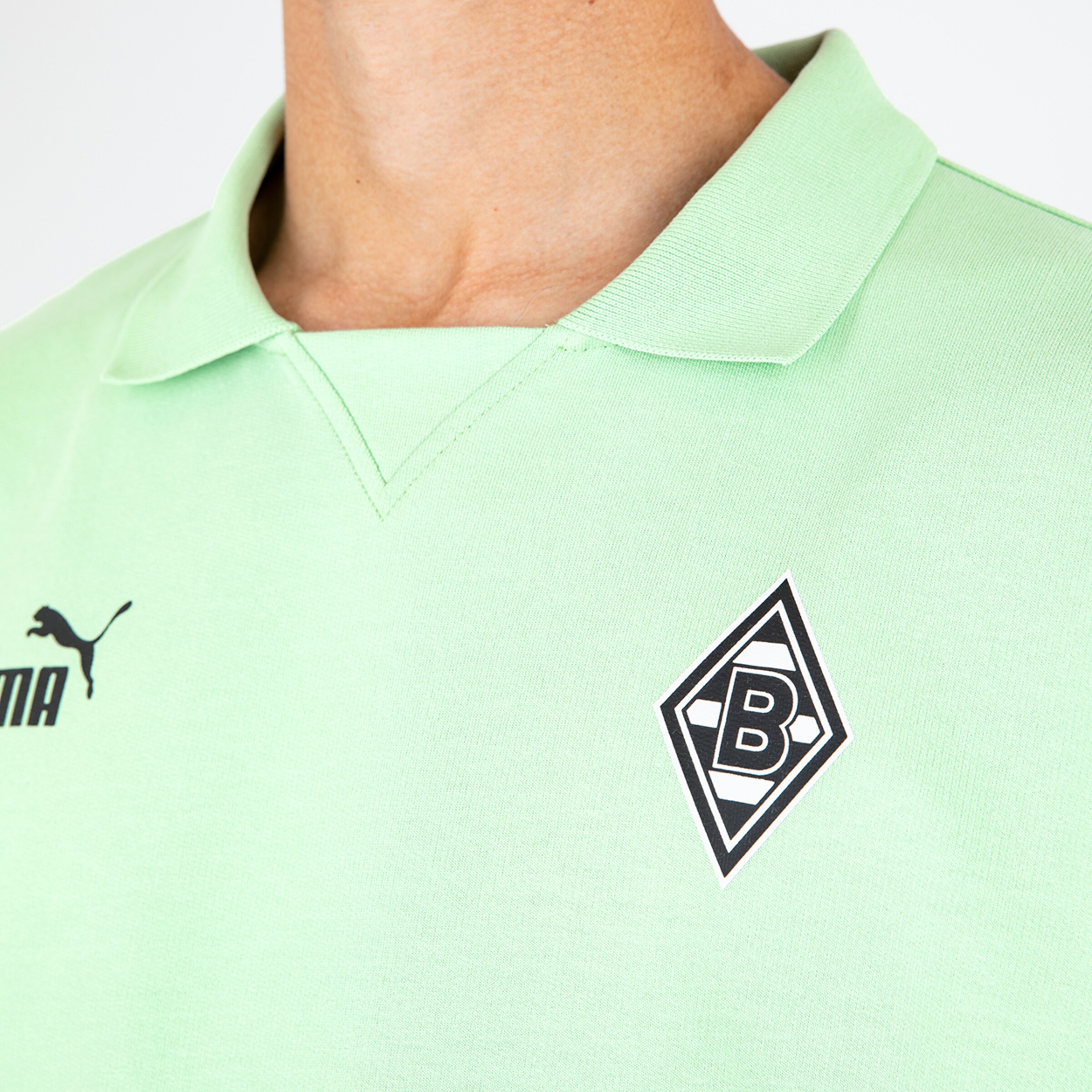 Puma jersey of Borussia Mönchengladbach in light green featuring the club logo.