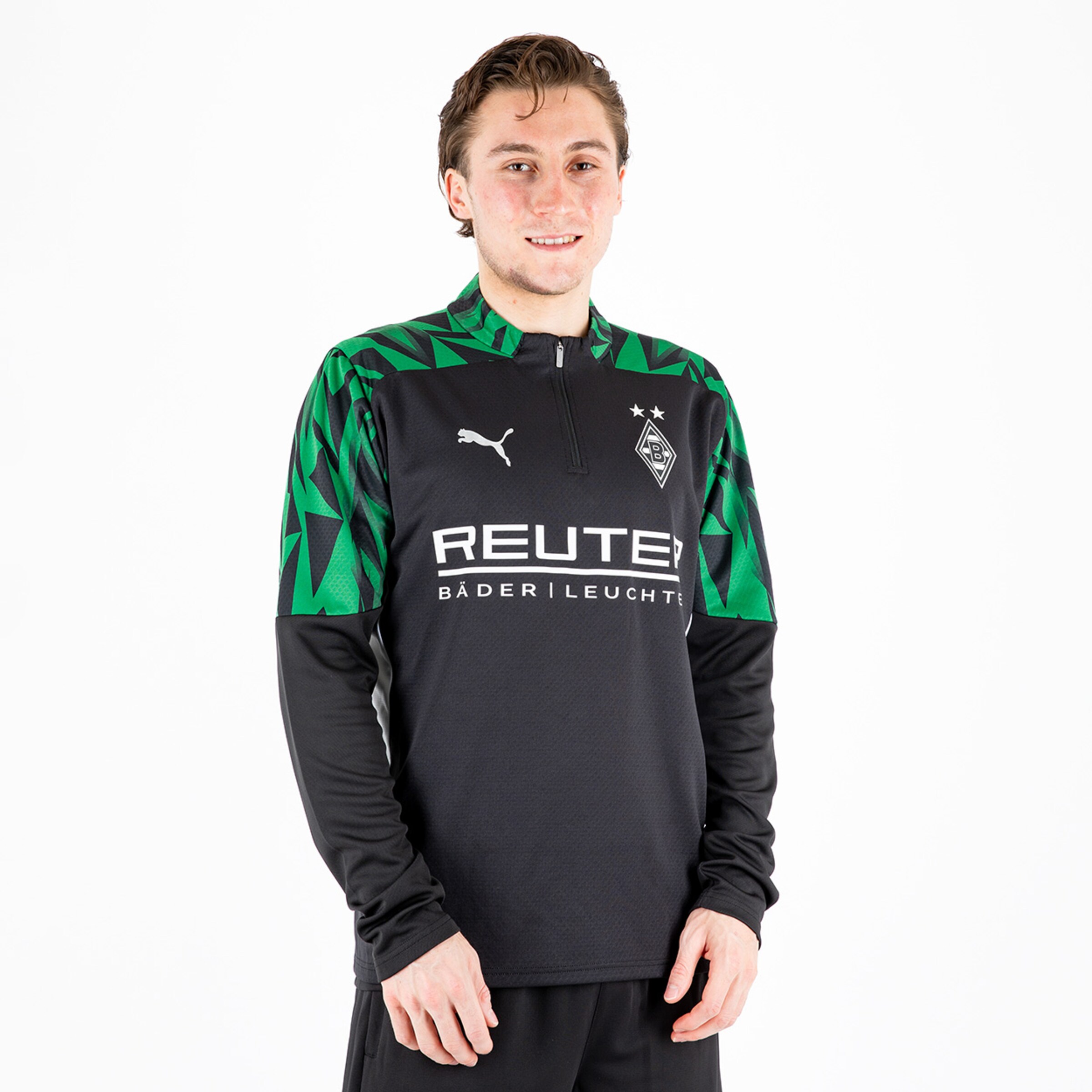 Player in black training top with green pattern wearing Puma logo and Borussia Mönchengladbach crest.