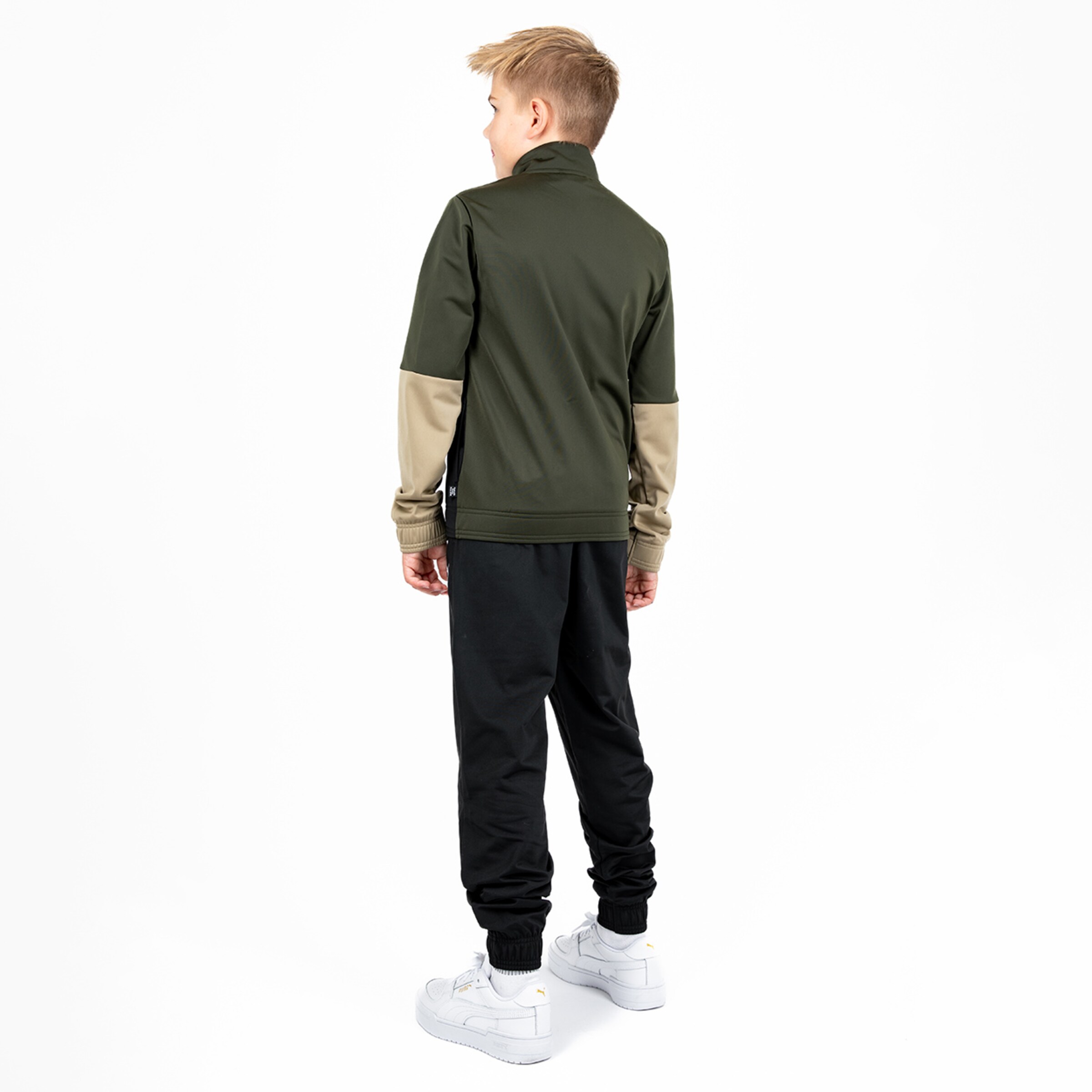 Junge mit Rückenansicht trägt olivegrüne Jacke und schwarze Jogginghose