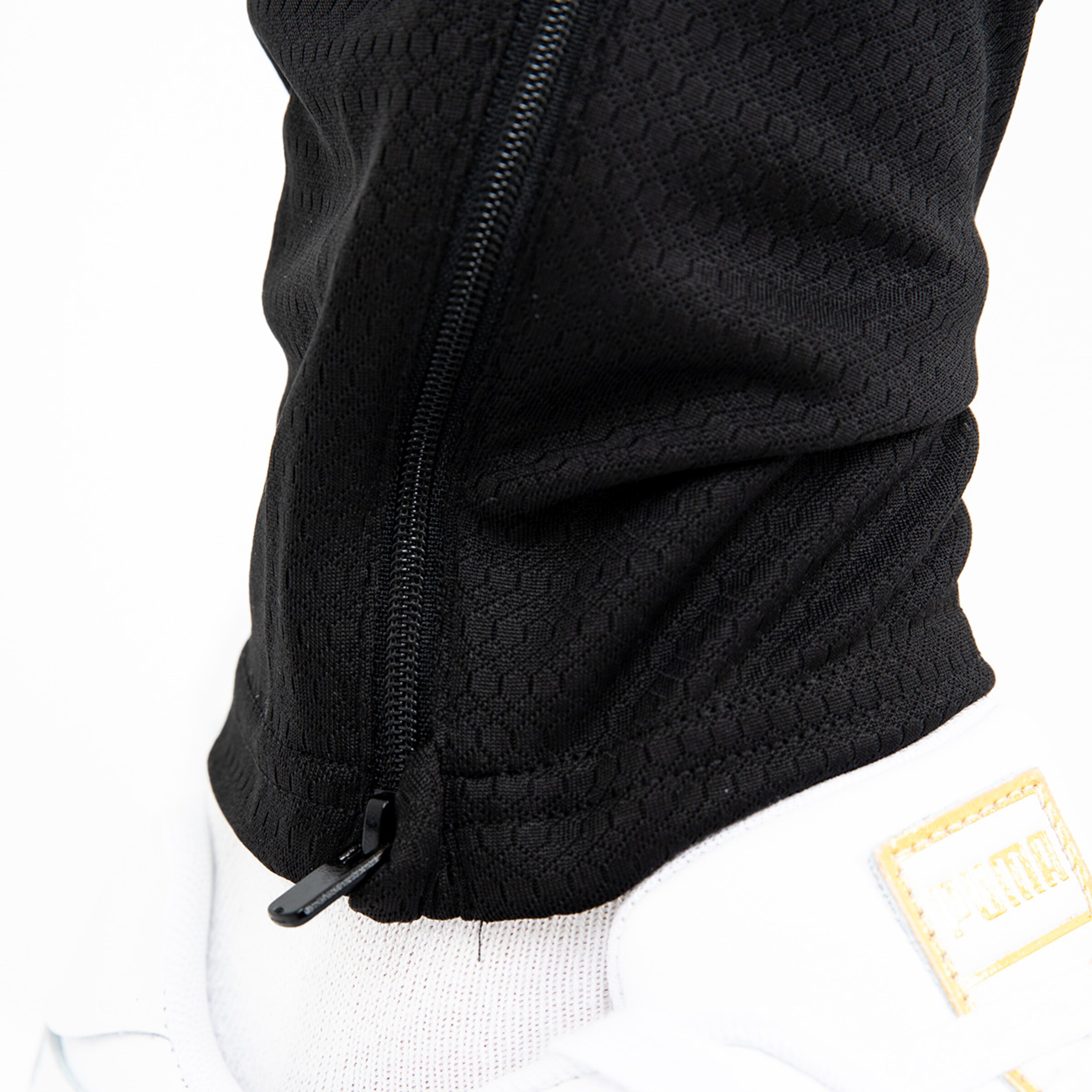 Detailaufnahme eines schwarzen Trainingsanzugs mit Reißverschluss.