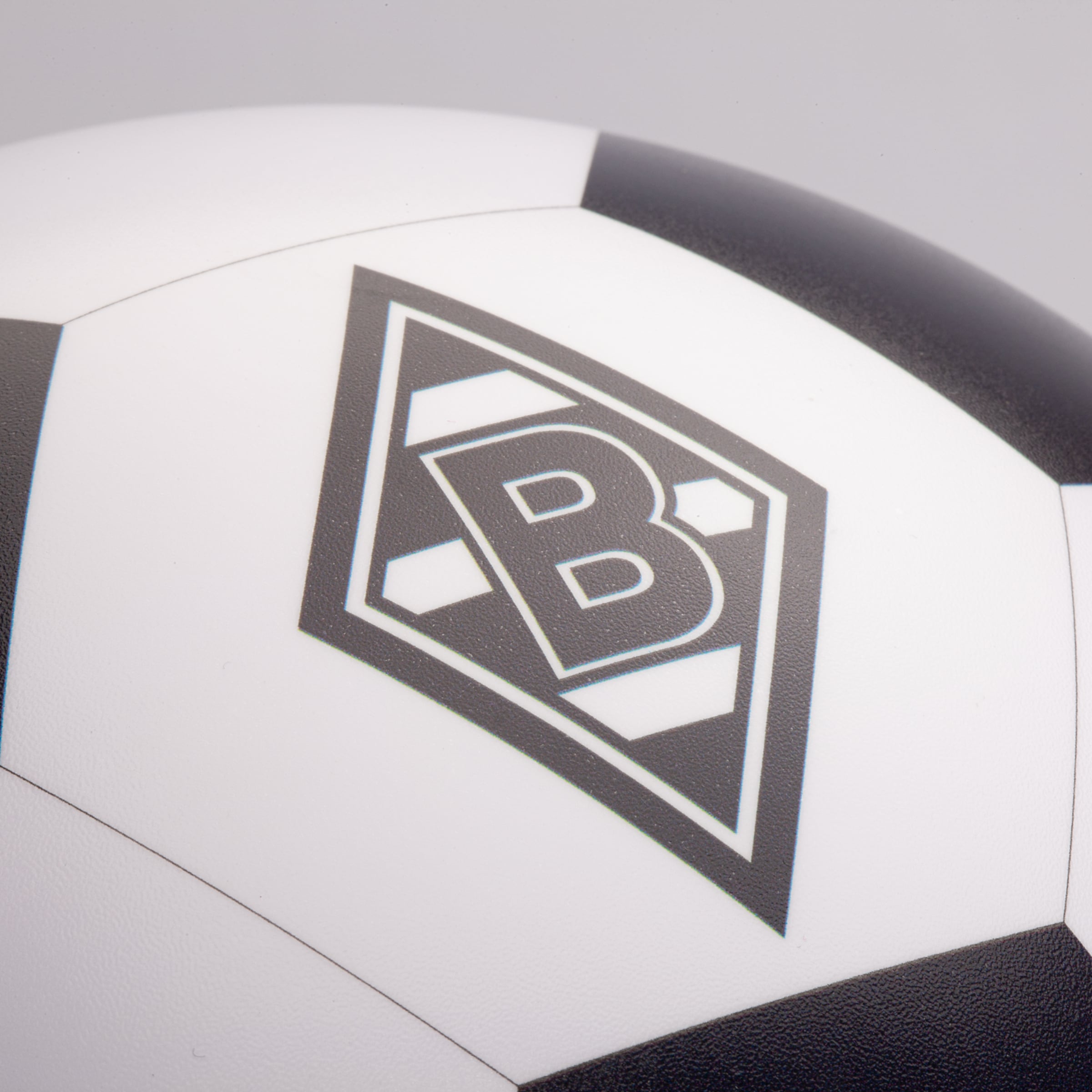 Nahaufnahme eines schwarz-weißen Fußballs mit dem Rautenlogo von Borussia Mönchengladbach auf einem weißen Feld.