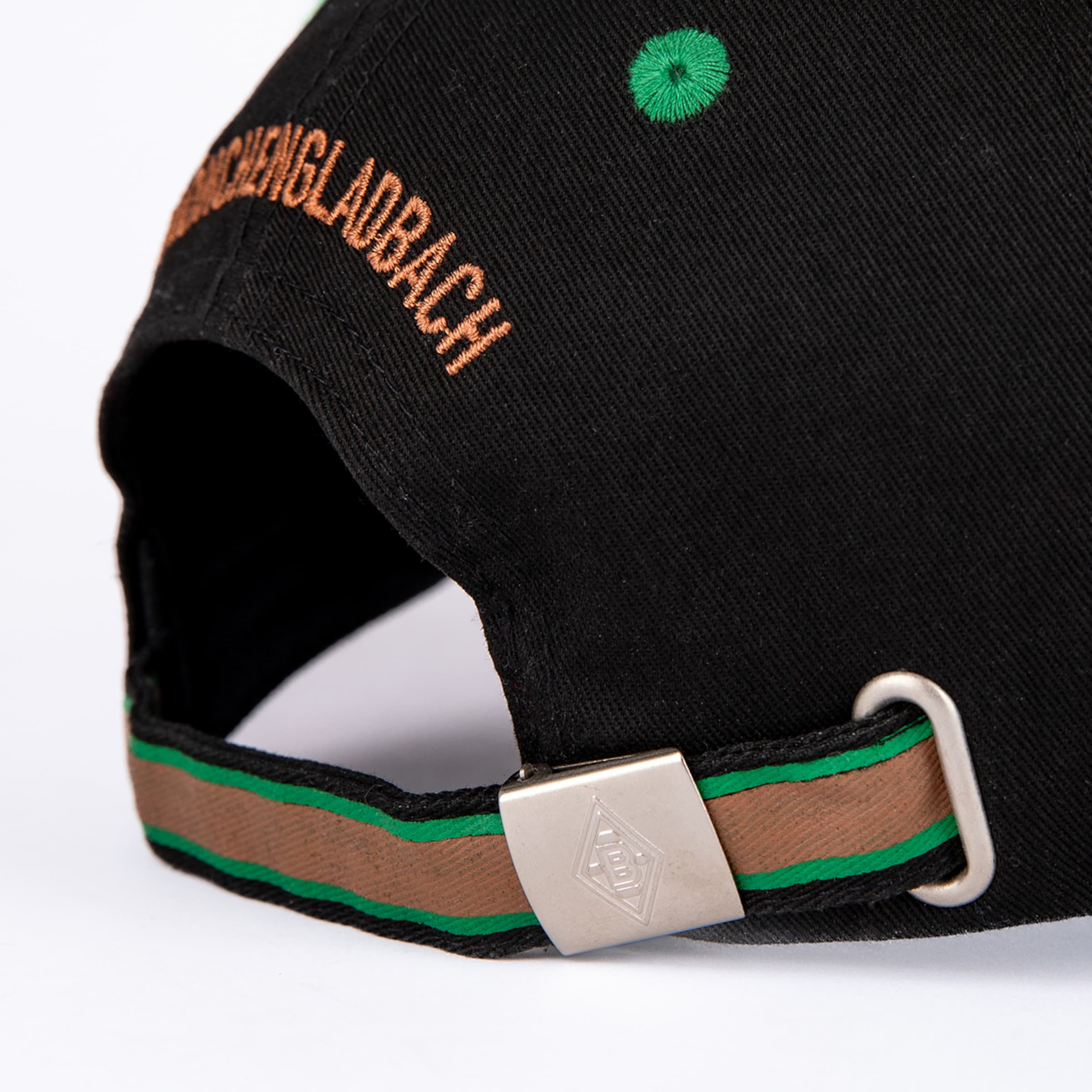 Rückansicht einer schwarzen Cap mit orangefarbenem „Mönchengladbach“-Stick und grün-braun gestreiftem Riemen mit Logo auf der Schnalle.