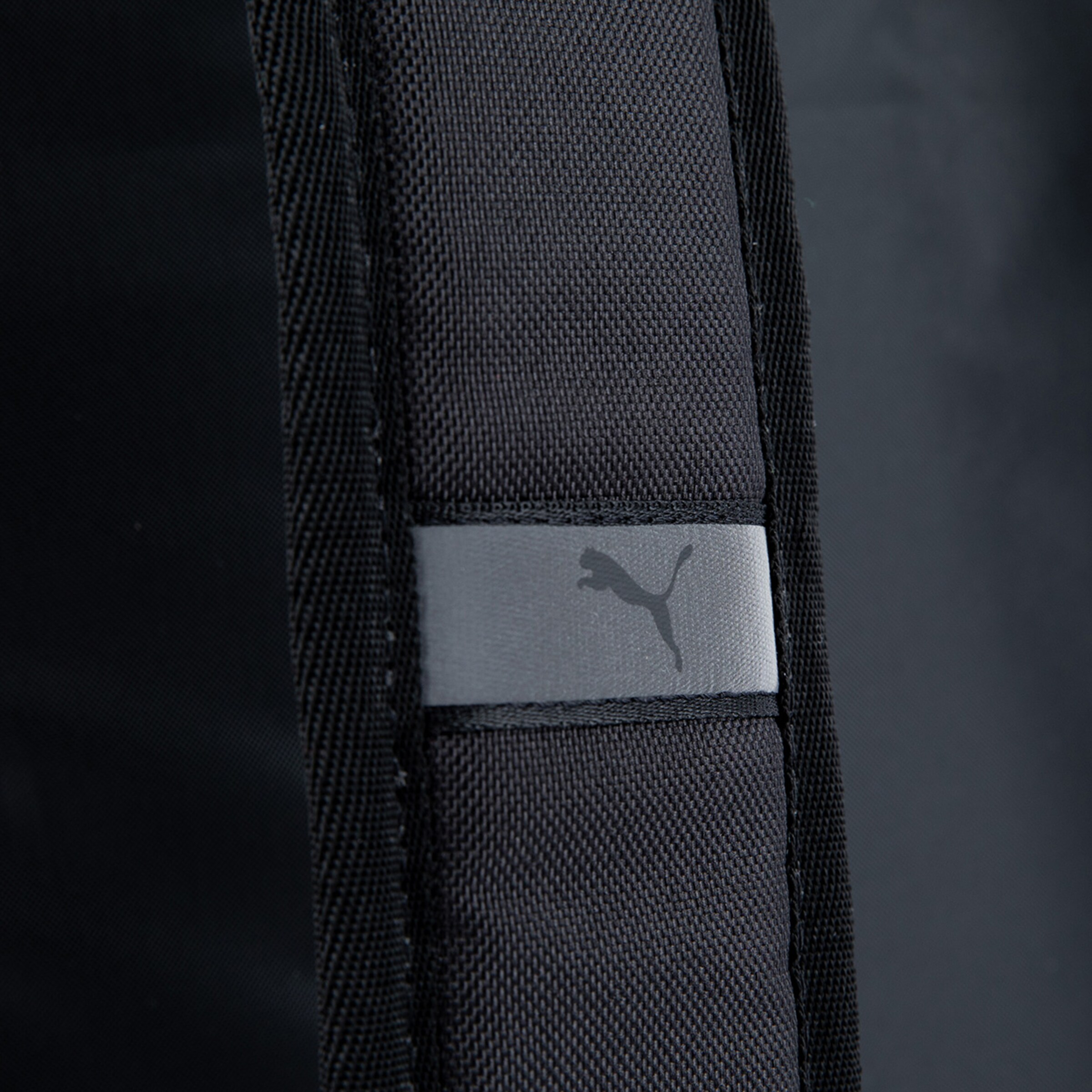 Schwarze Tasche mit Puma-Logo auf grauem Patch.