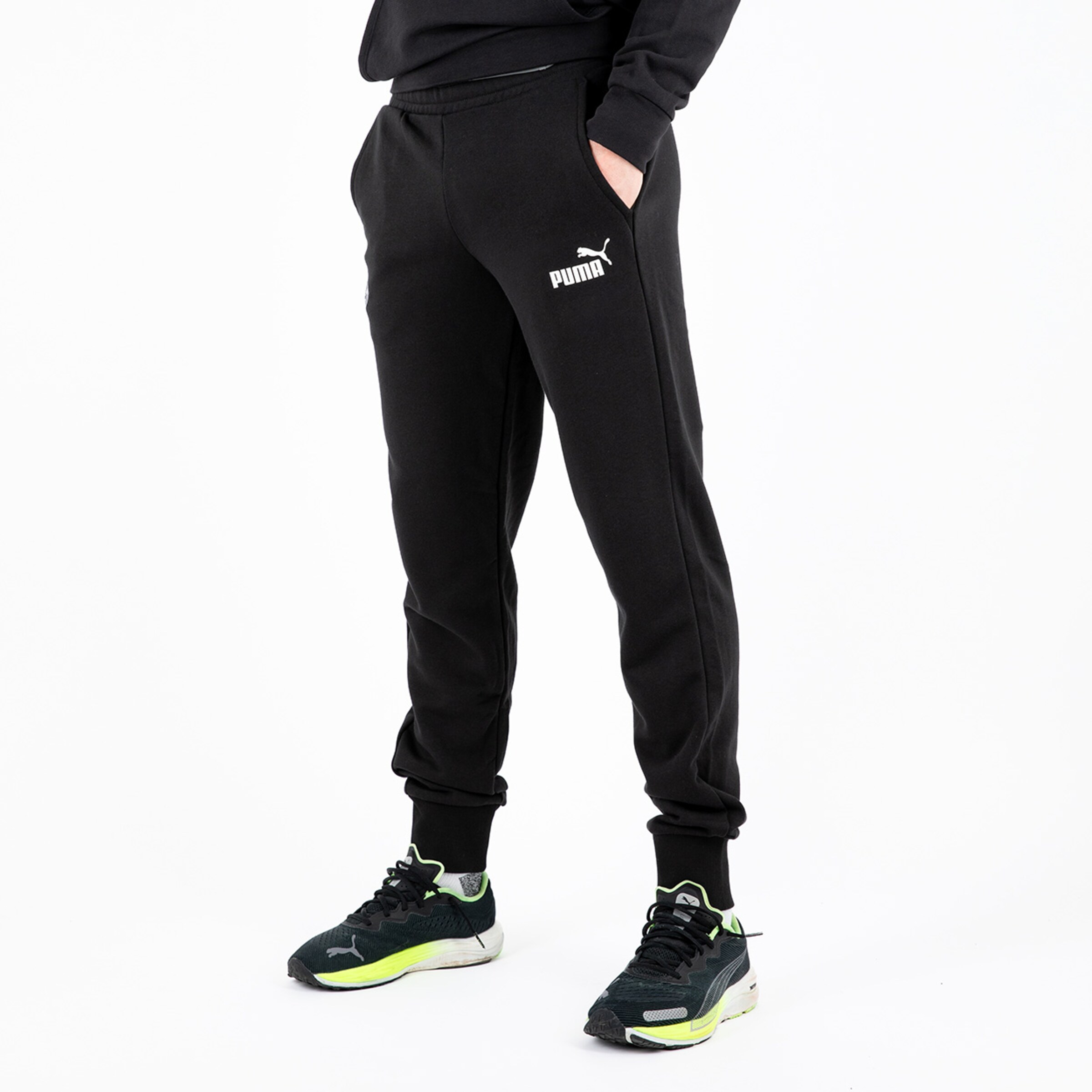 Schwarze Puma Jogginghose Träger steht seitlich.