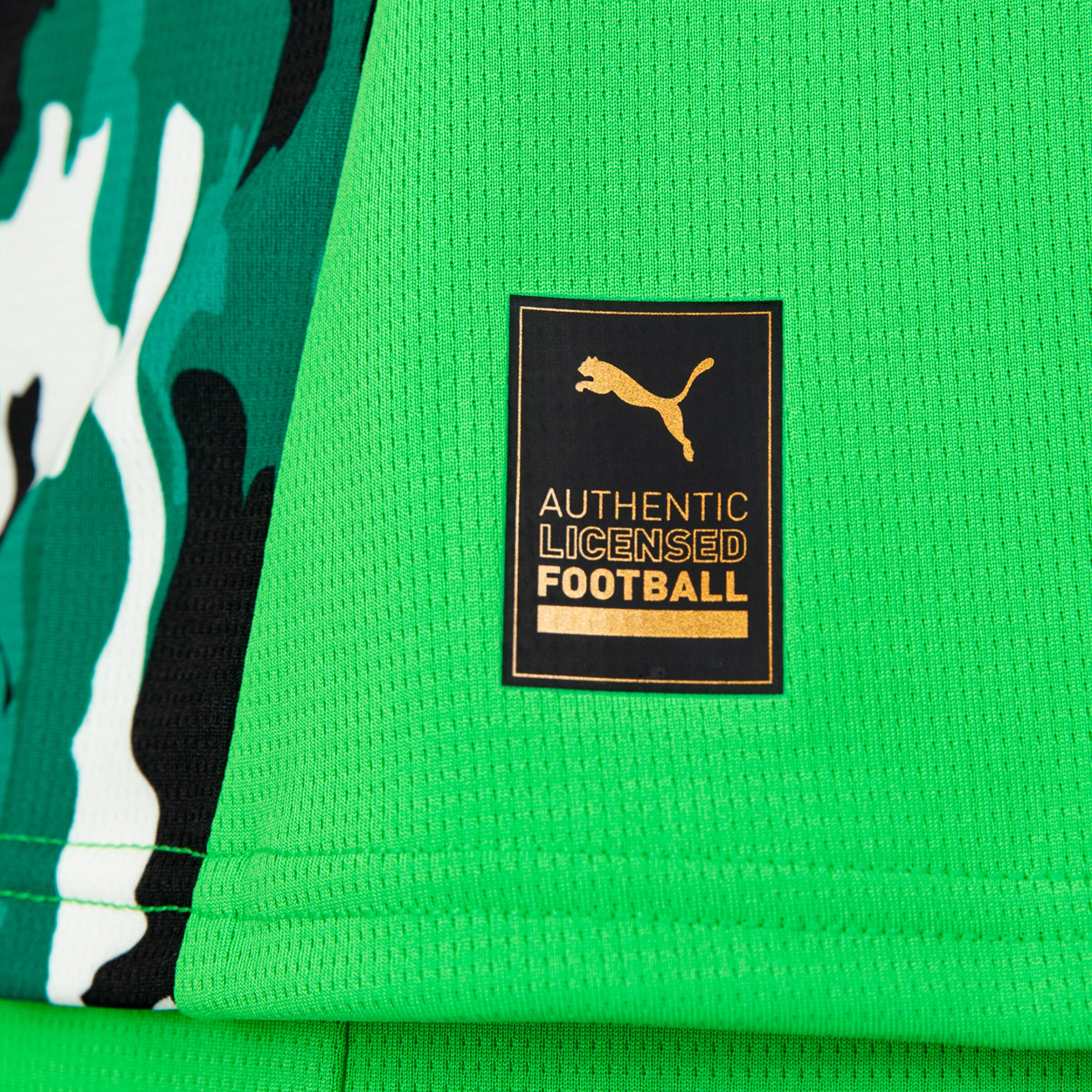 Puma licensing tag on a green football kit