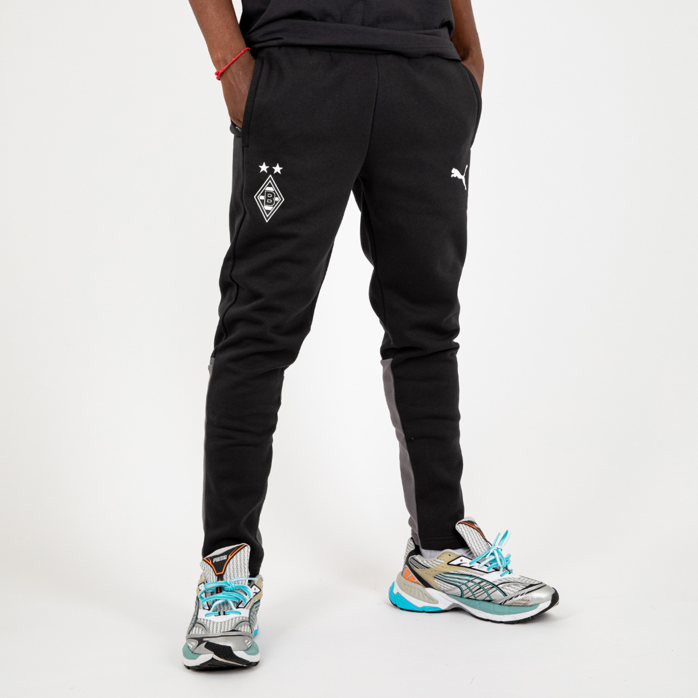 Schwarze Trainingshose von Borussia Mönchengladbach mit Logo und PUMA-Emblem.