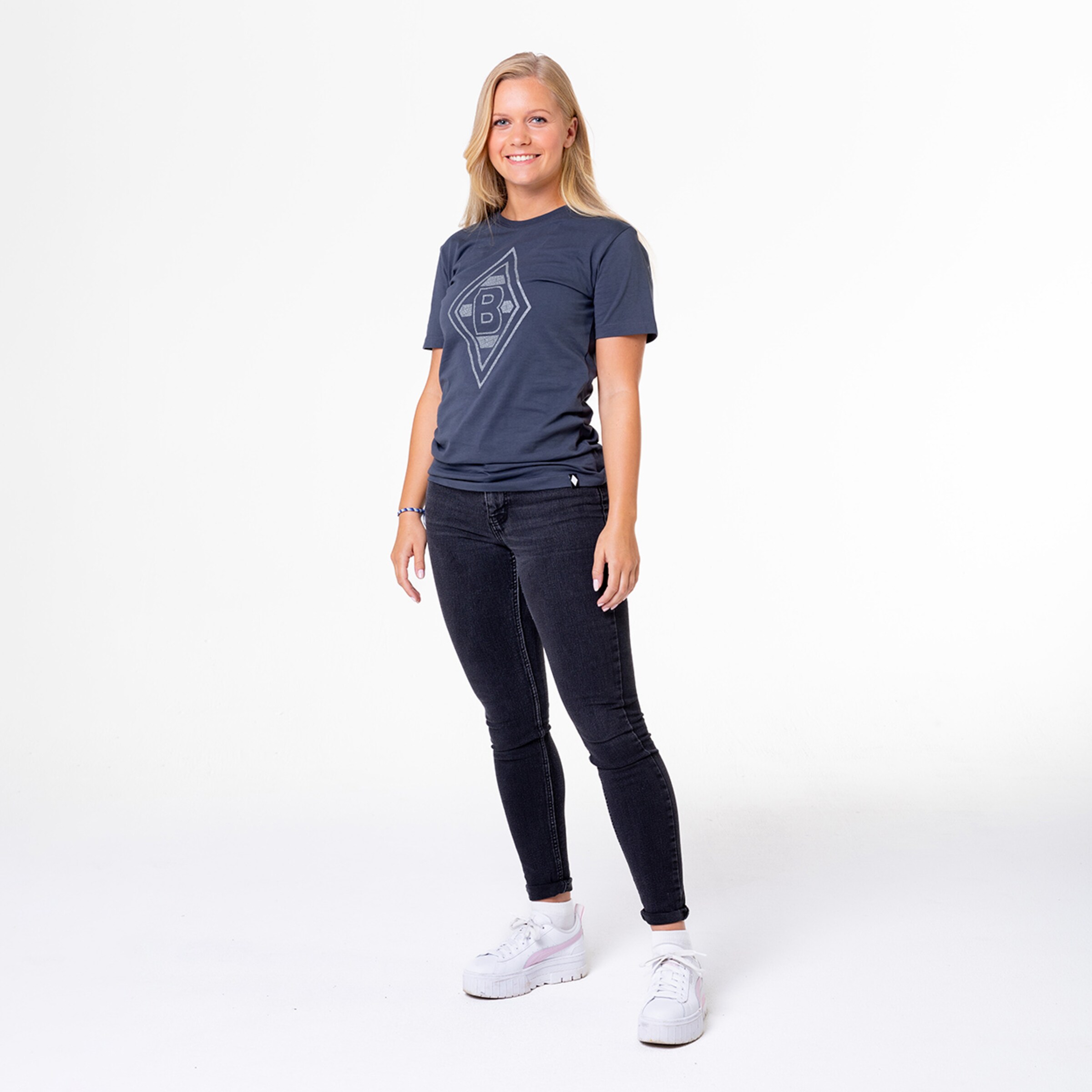 Junge Frau steht in einem sportlichen Outfit mit Borussia Mönchengladbach-Logo.